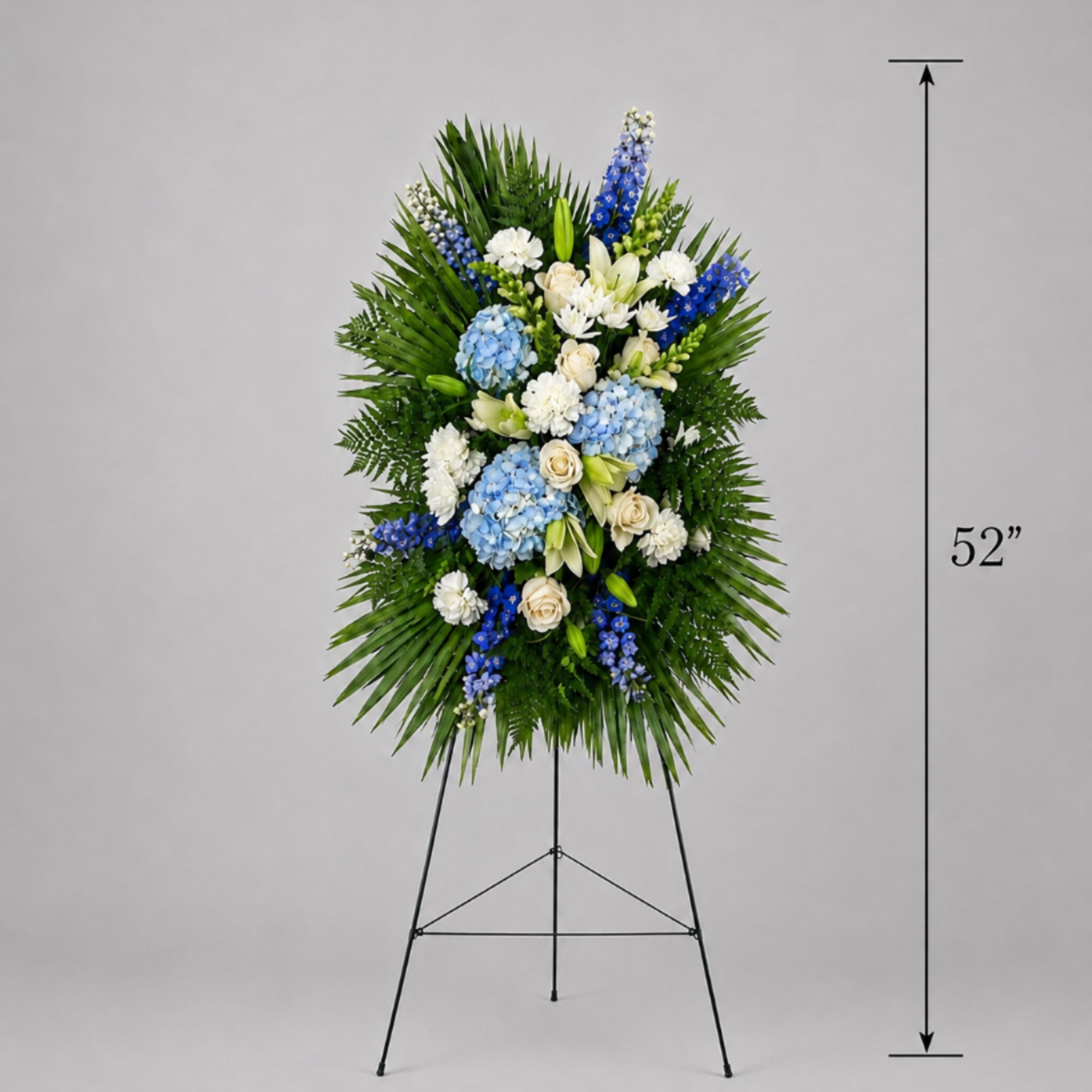 Tall blue and white funeral spray on a stand