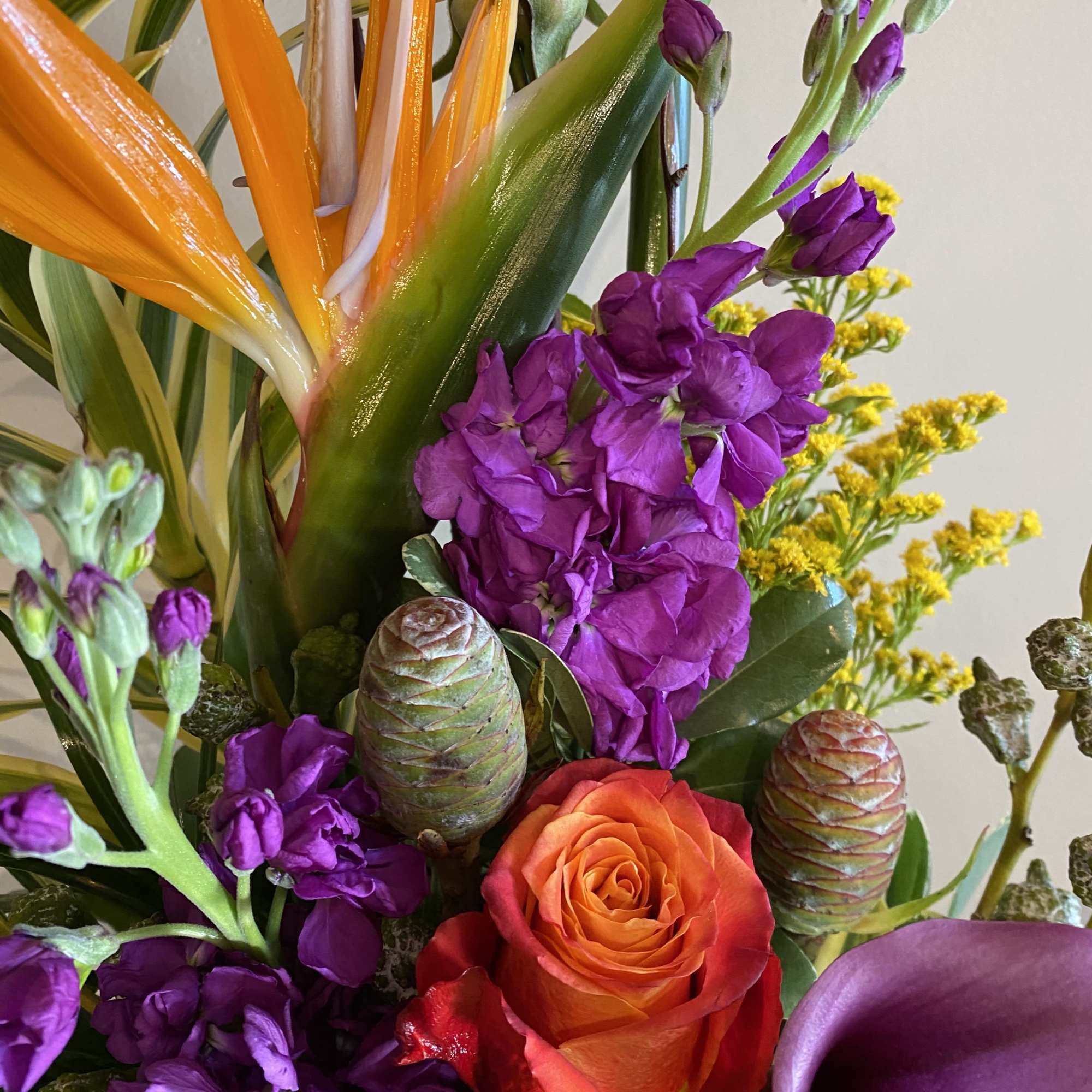 Tropical bouquet with orange bird of paradise, purple blooms, and a calla lily
