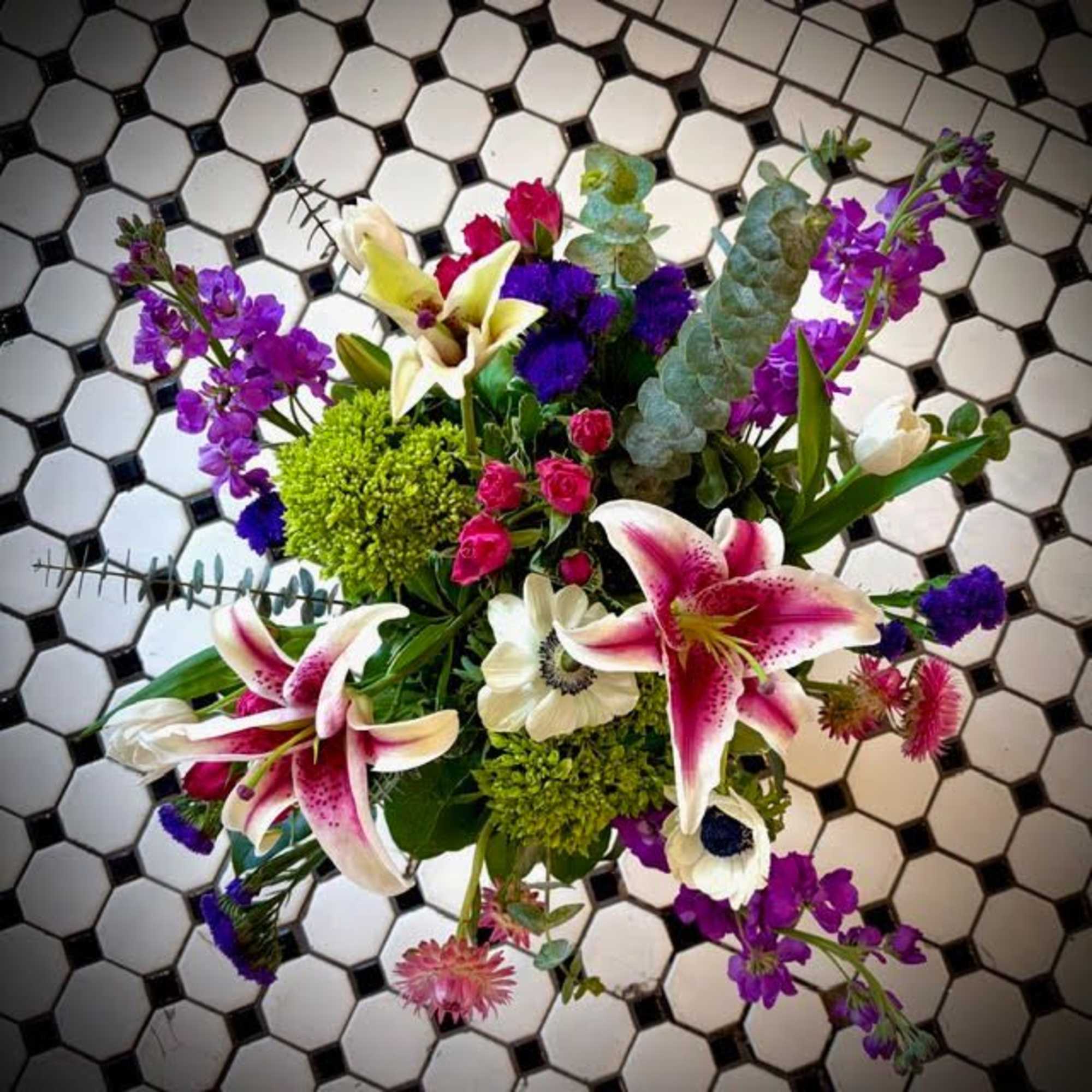 A stunning garden design with stargazer lilies, tulips, spray roses, hydrangea, and