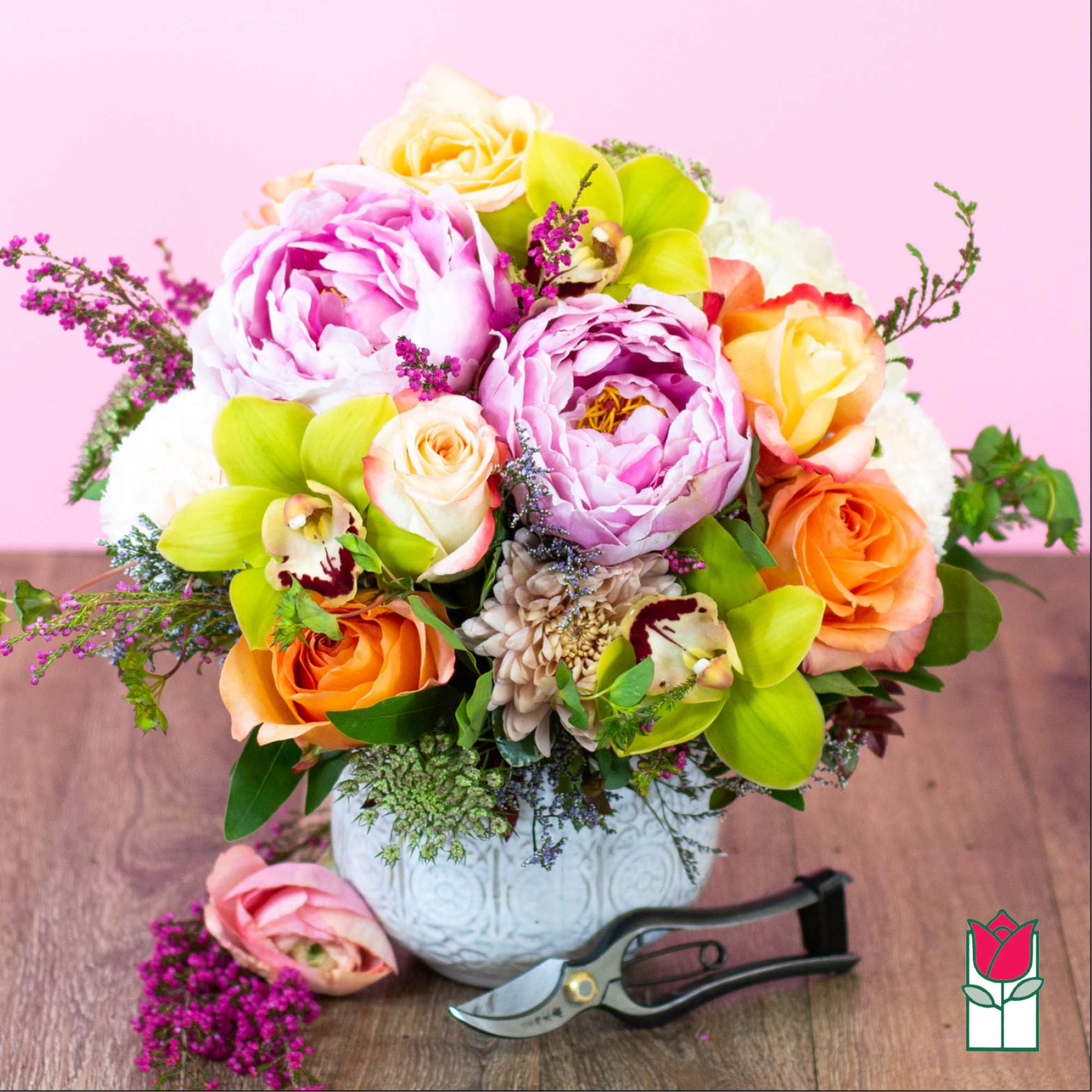 Pink and orange floral arrangement in a white vase