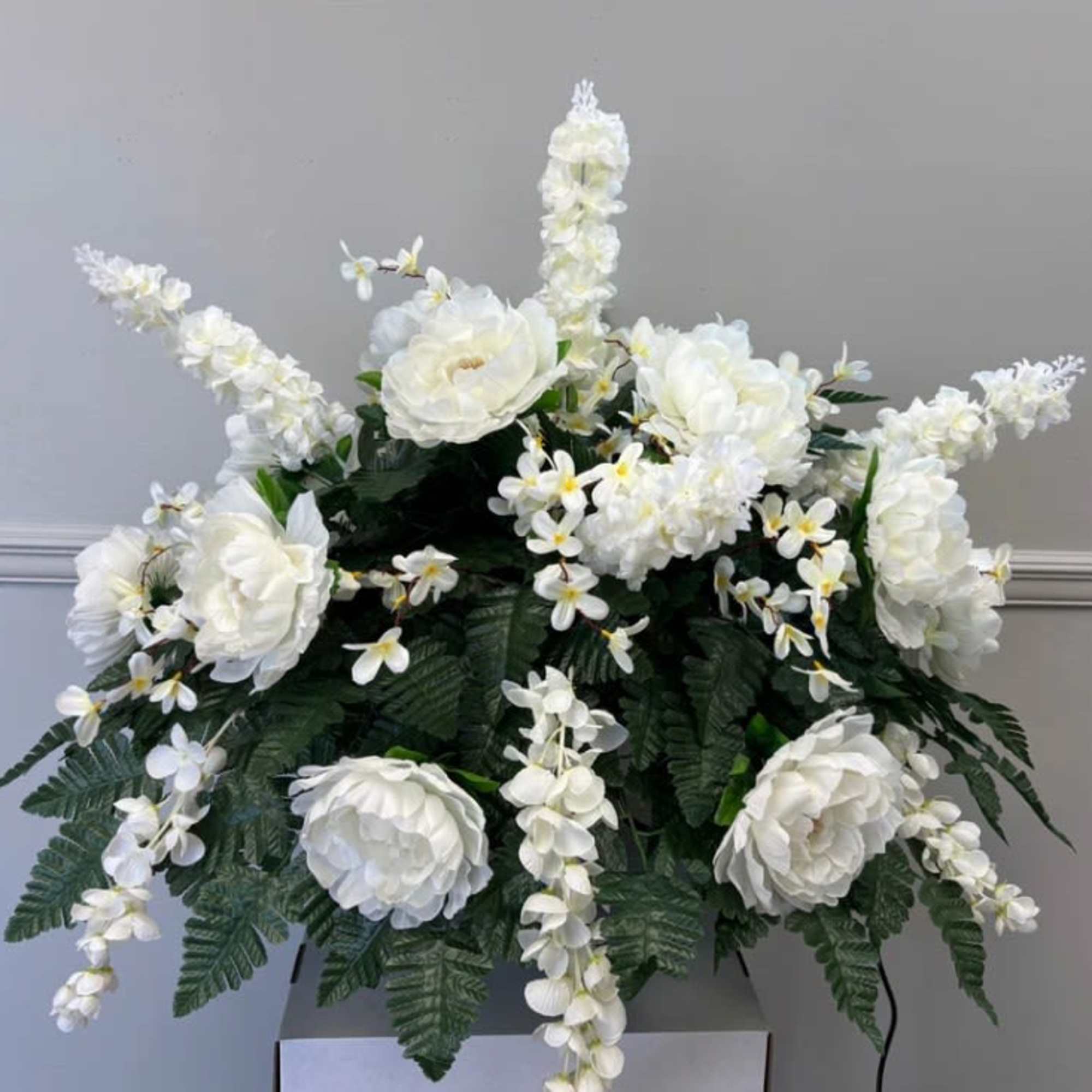White floral arrangement with large blooms and cascading sprays