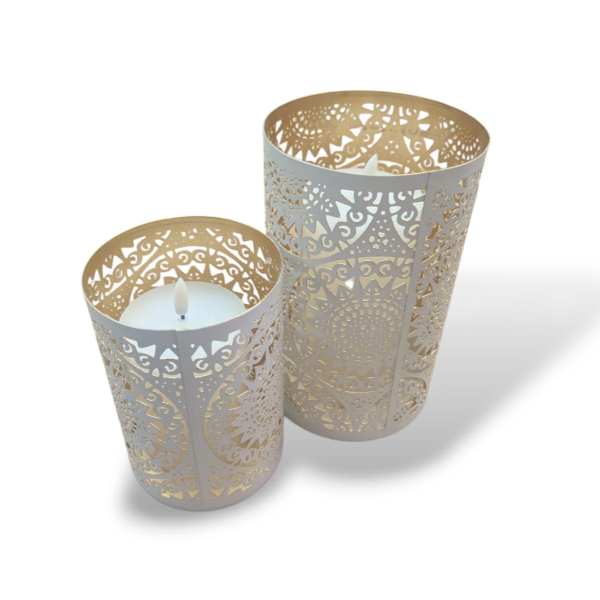 Two decorative white candles in ornate metal holders