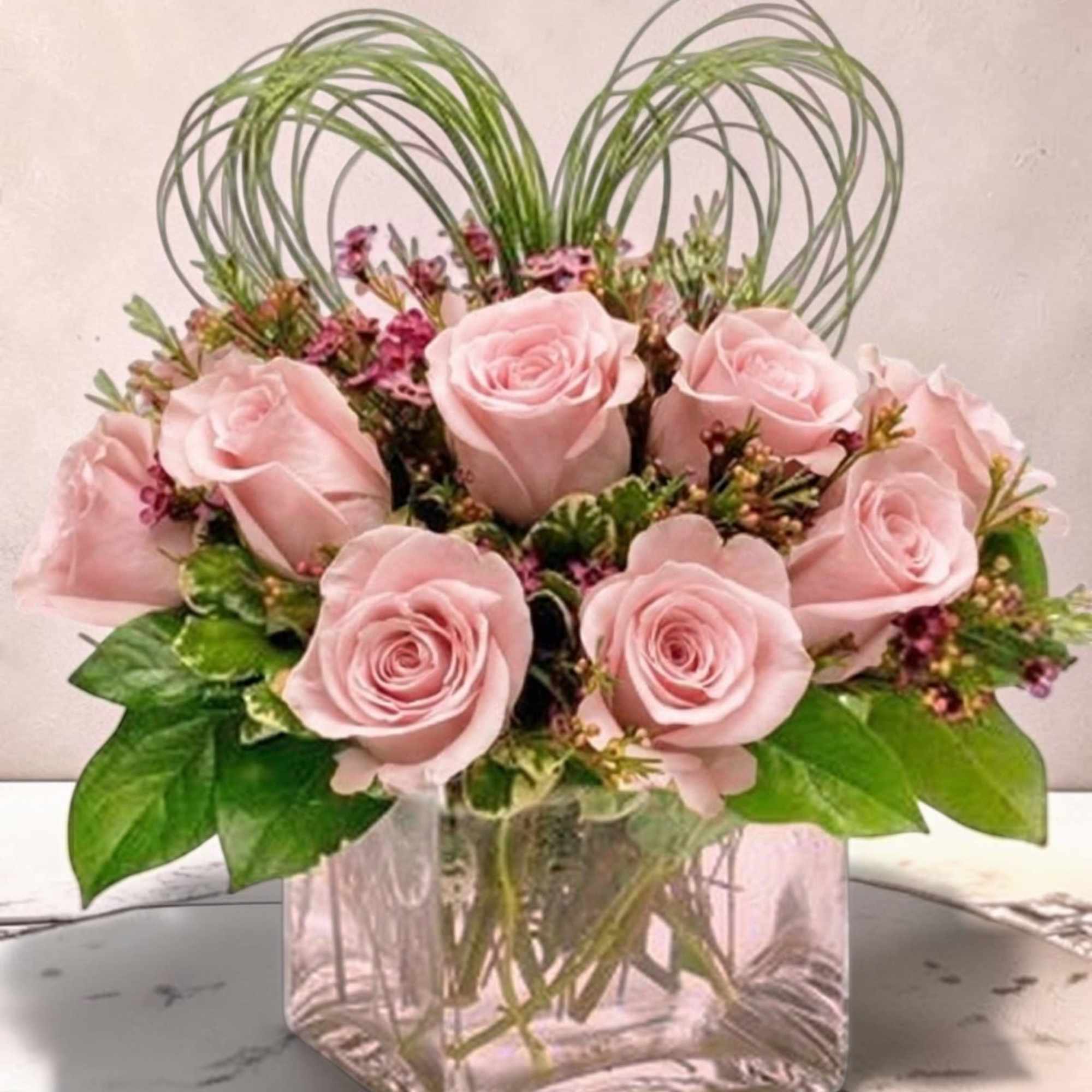 
This elegant floral arrangement features a compact cluster of rich red roses