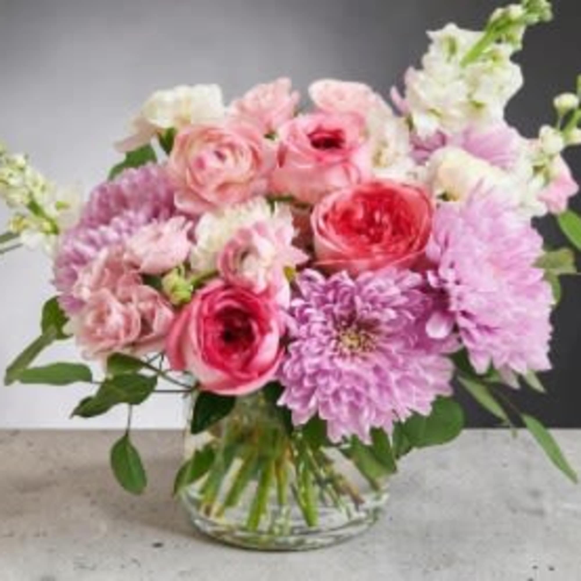 A lush, garden-style arrangement bursting with soft romance, this design features layered