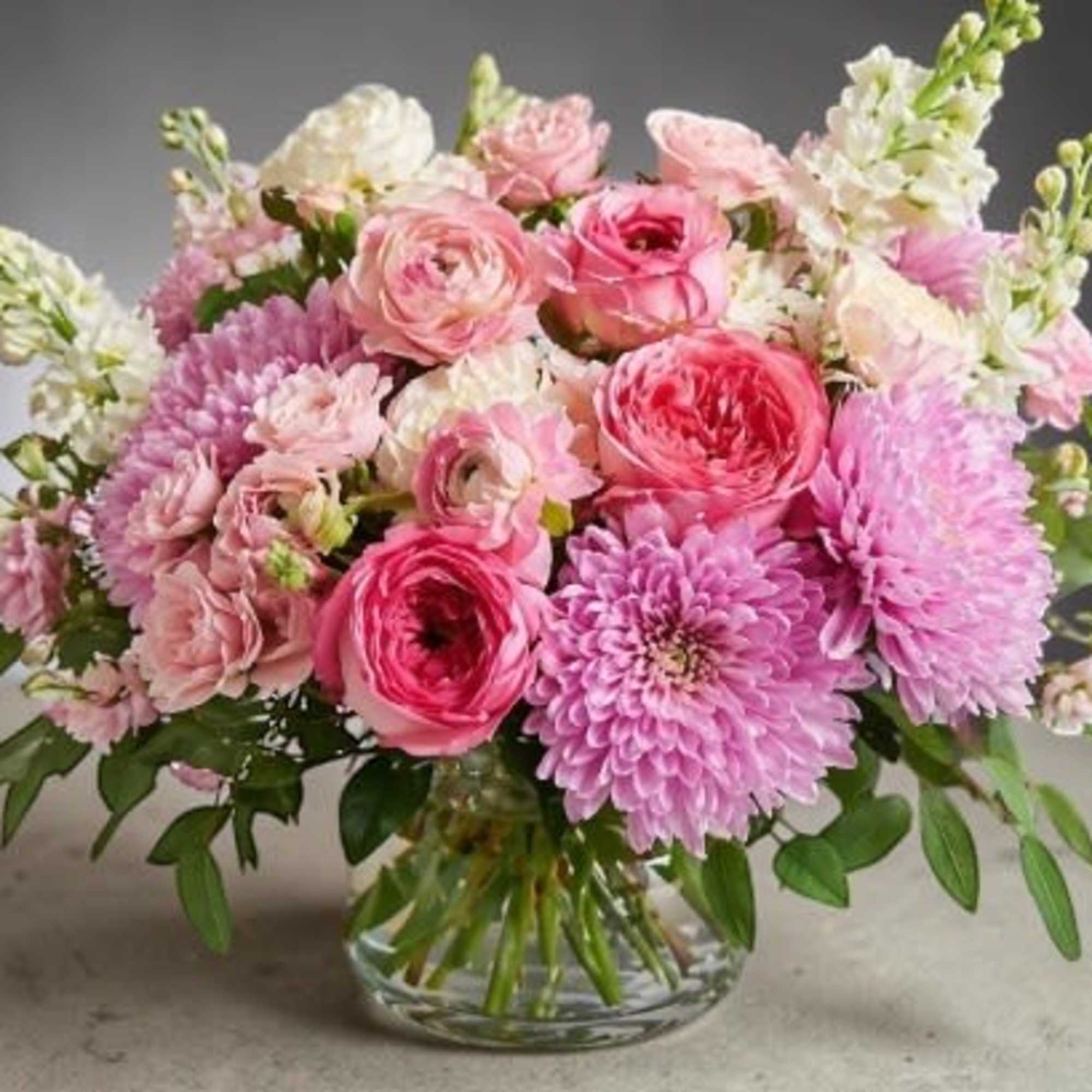 A lush, garden-style arrangement bursting with soft romance, this design features layered