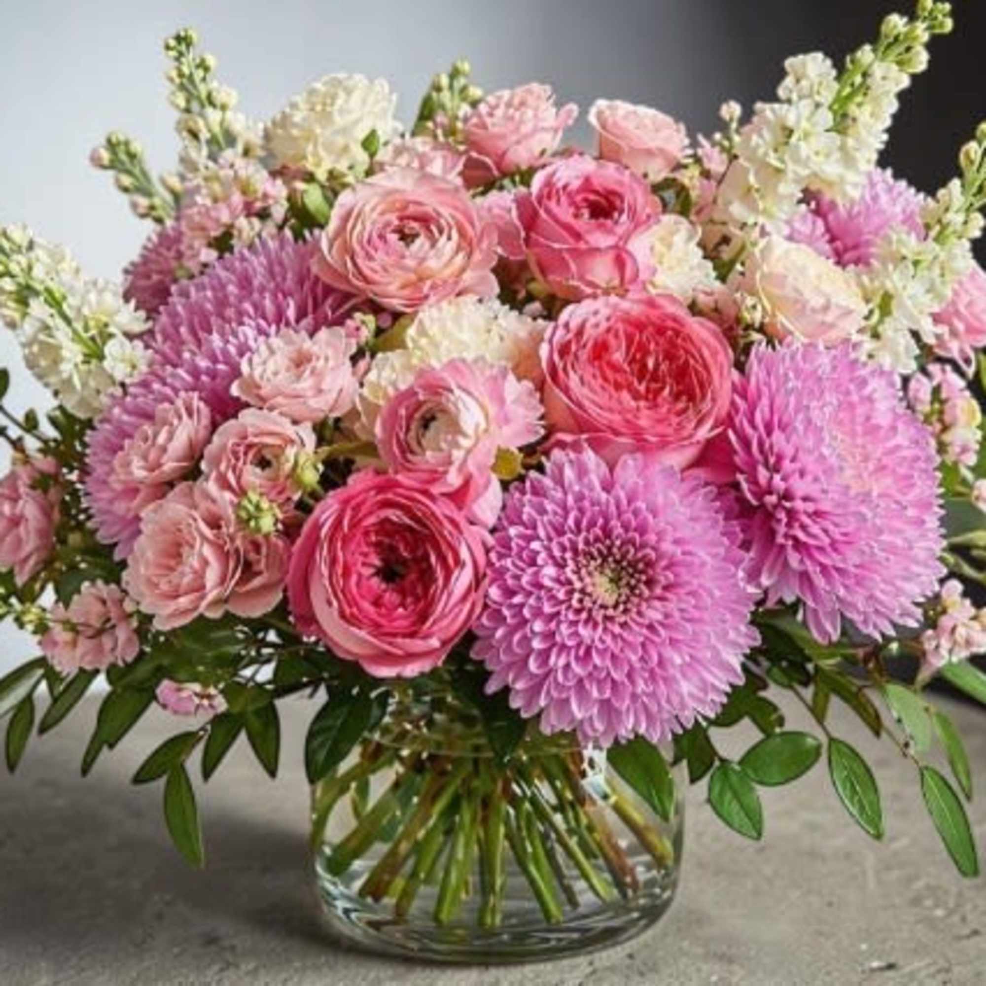 A lush, garden-style arrangement bursting with soft romance, this design features layered