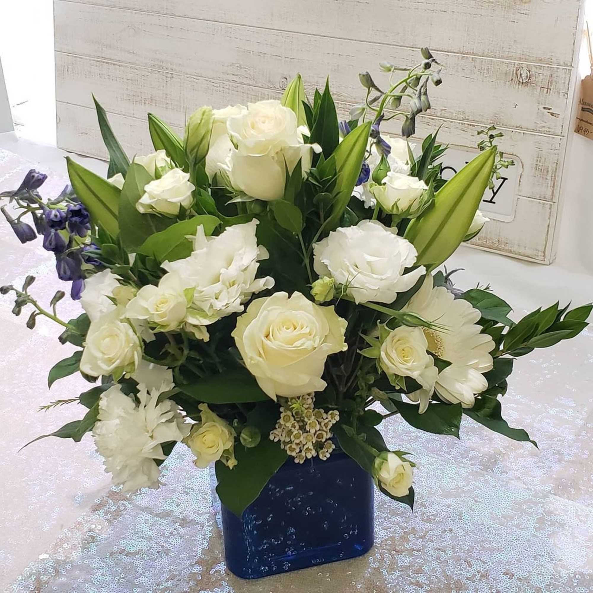 White rose and lily bouquet in a blue vase