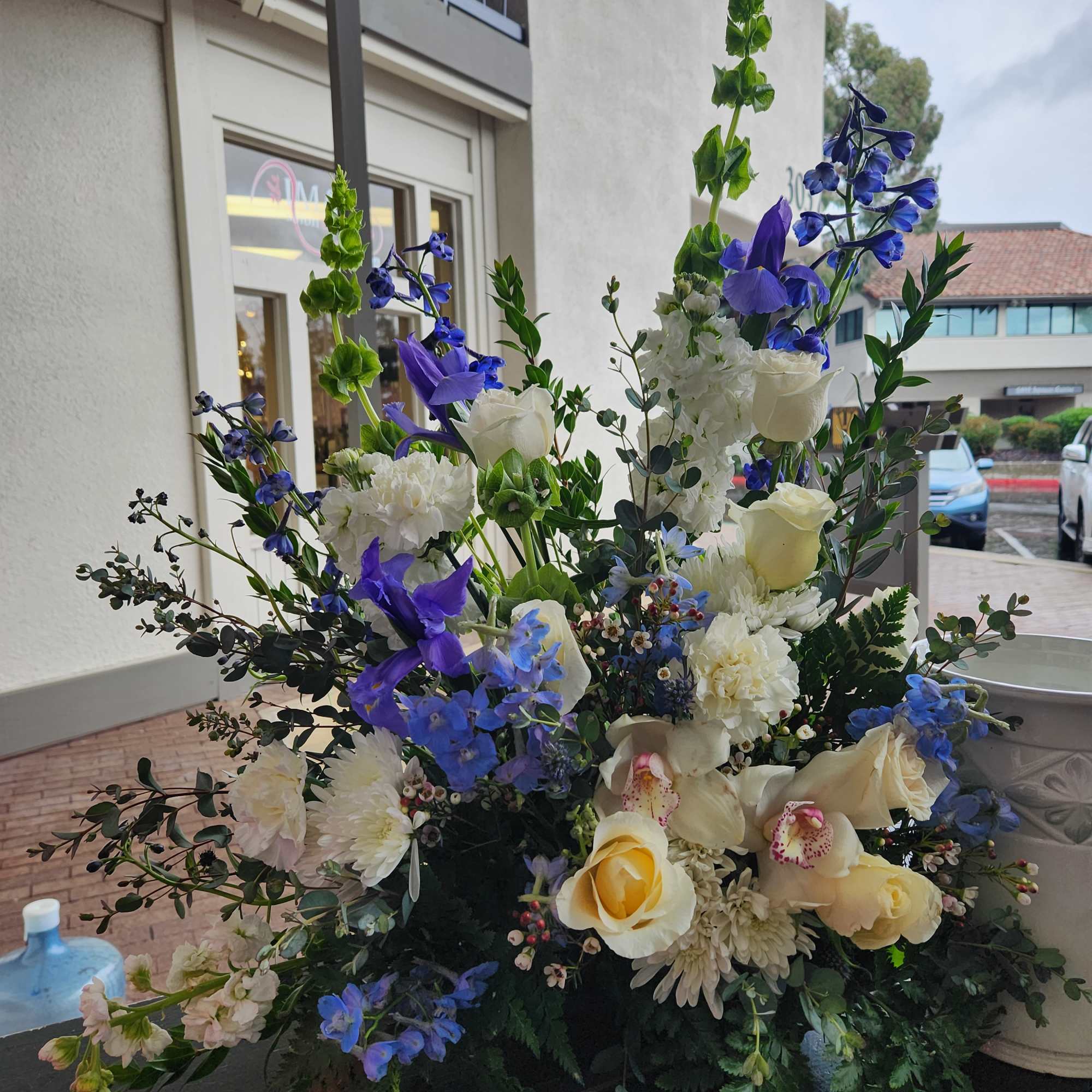 Large floral arrangement with white, blue, and yellow blooms