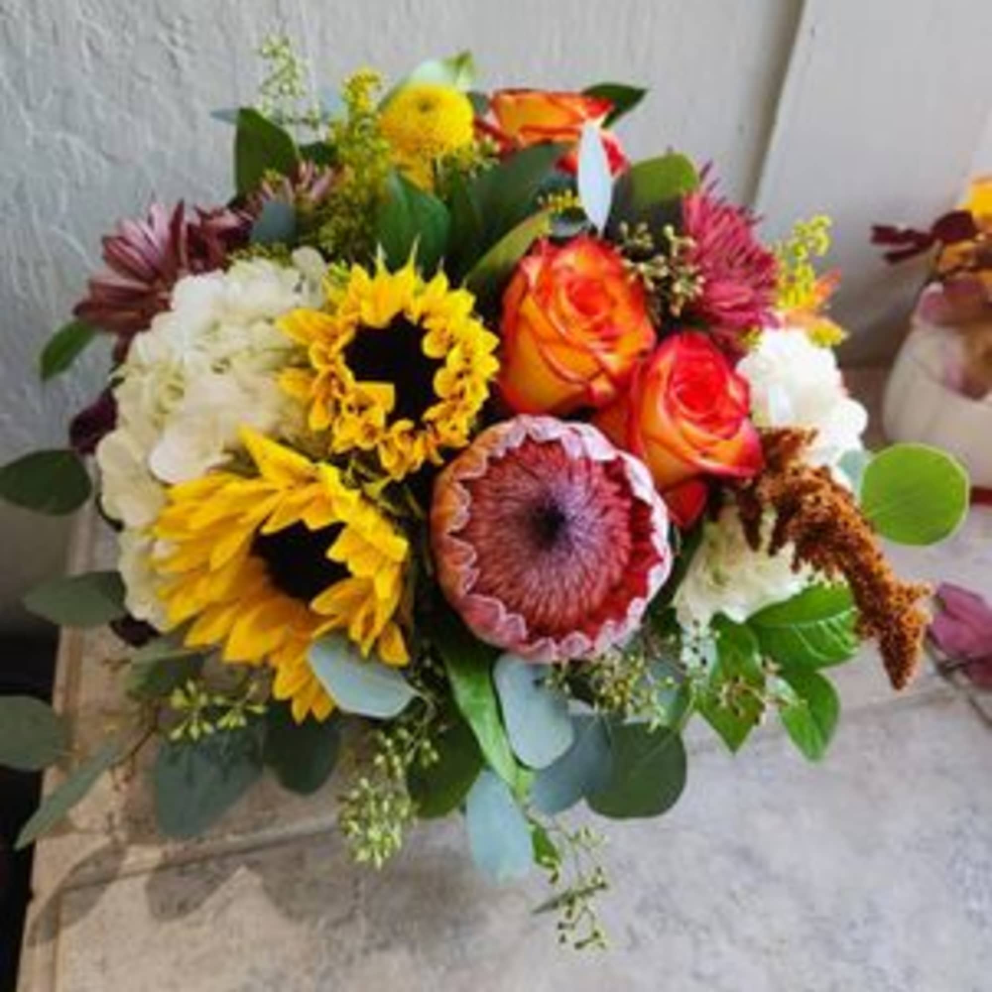Mixed bouquet with sunflowers, orange roses, and white blooms
