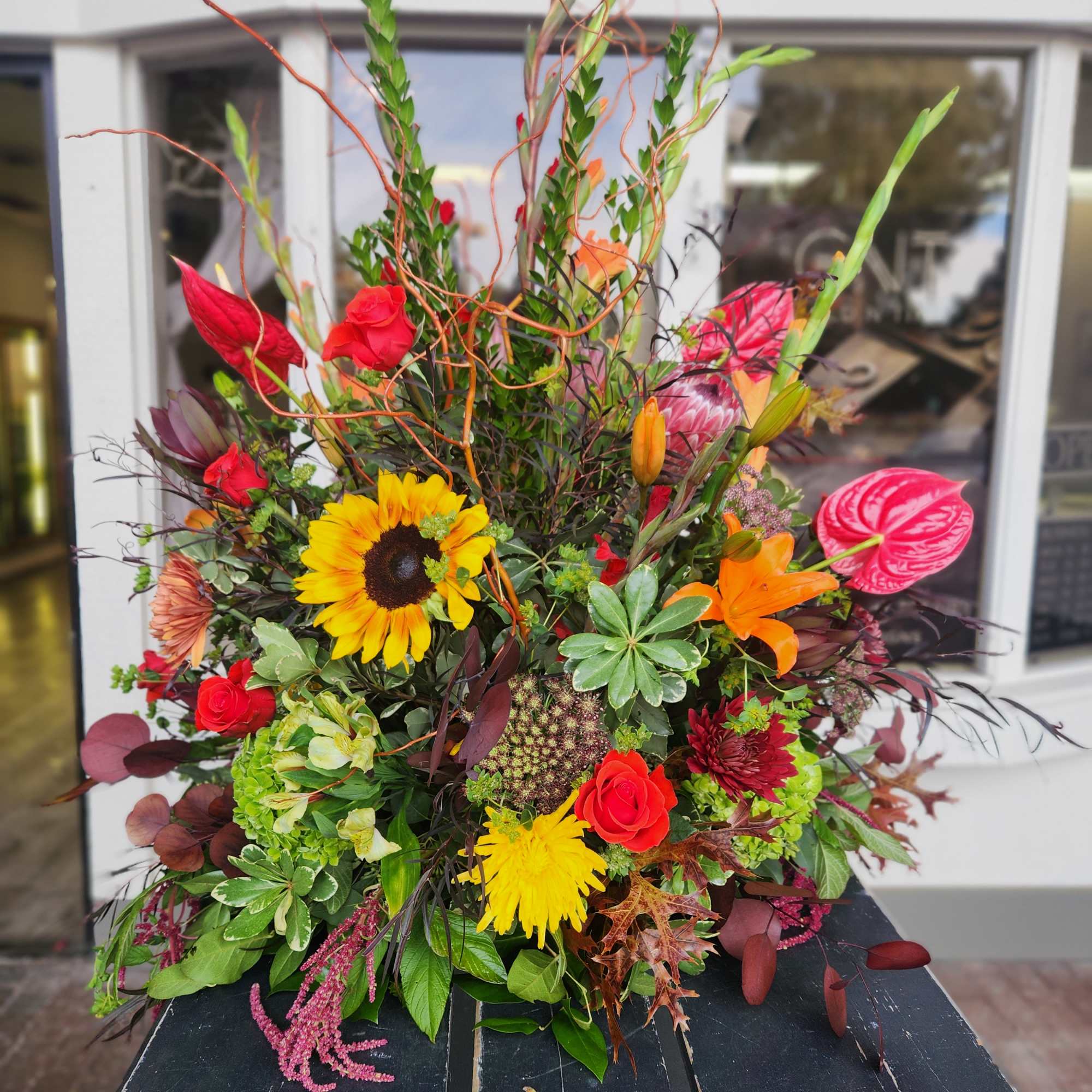 Colorful mixed floral arrangement with sunflowers, roses, lilies, and anthuriums