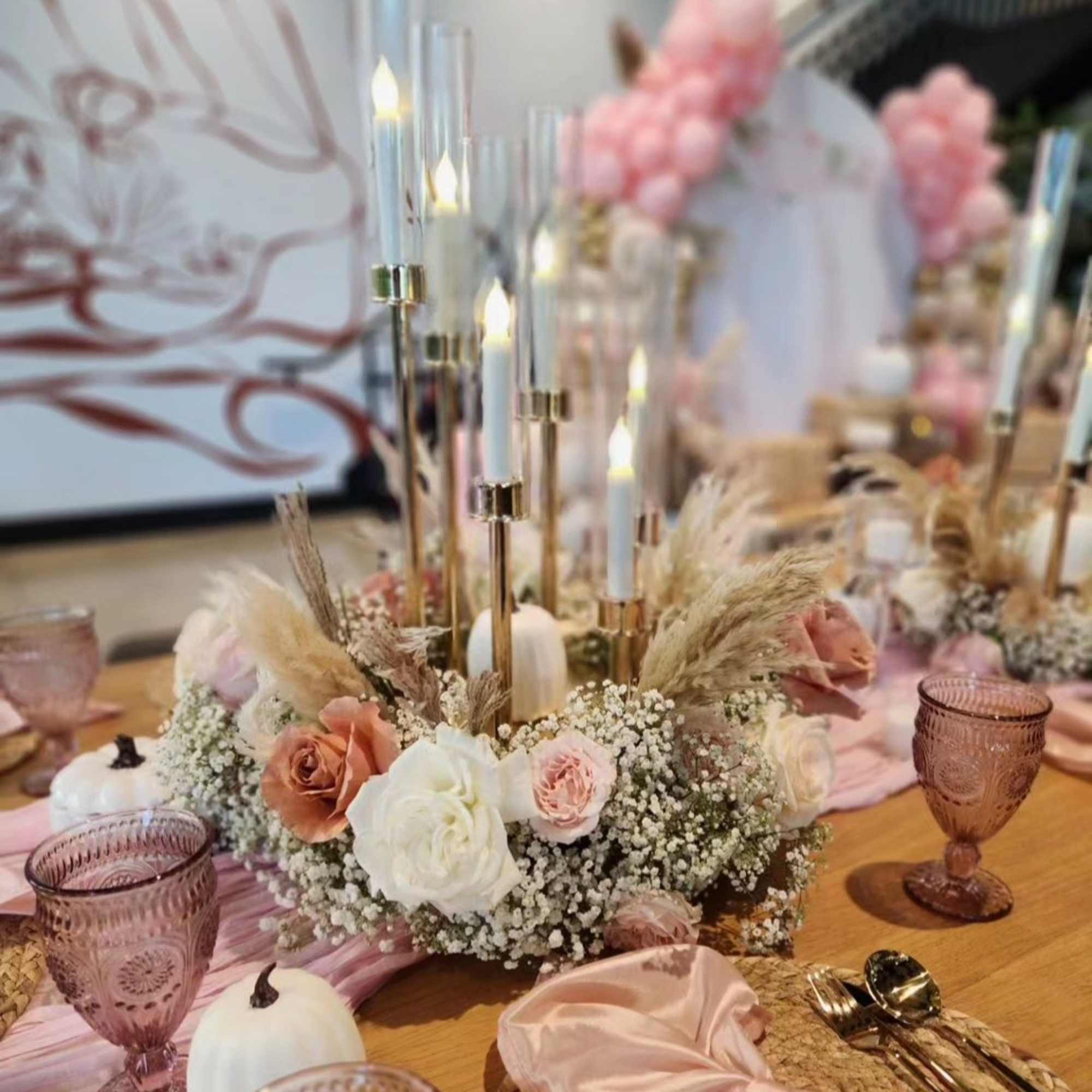 Pink and white rose centerpiece with candles on a table
