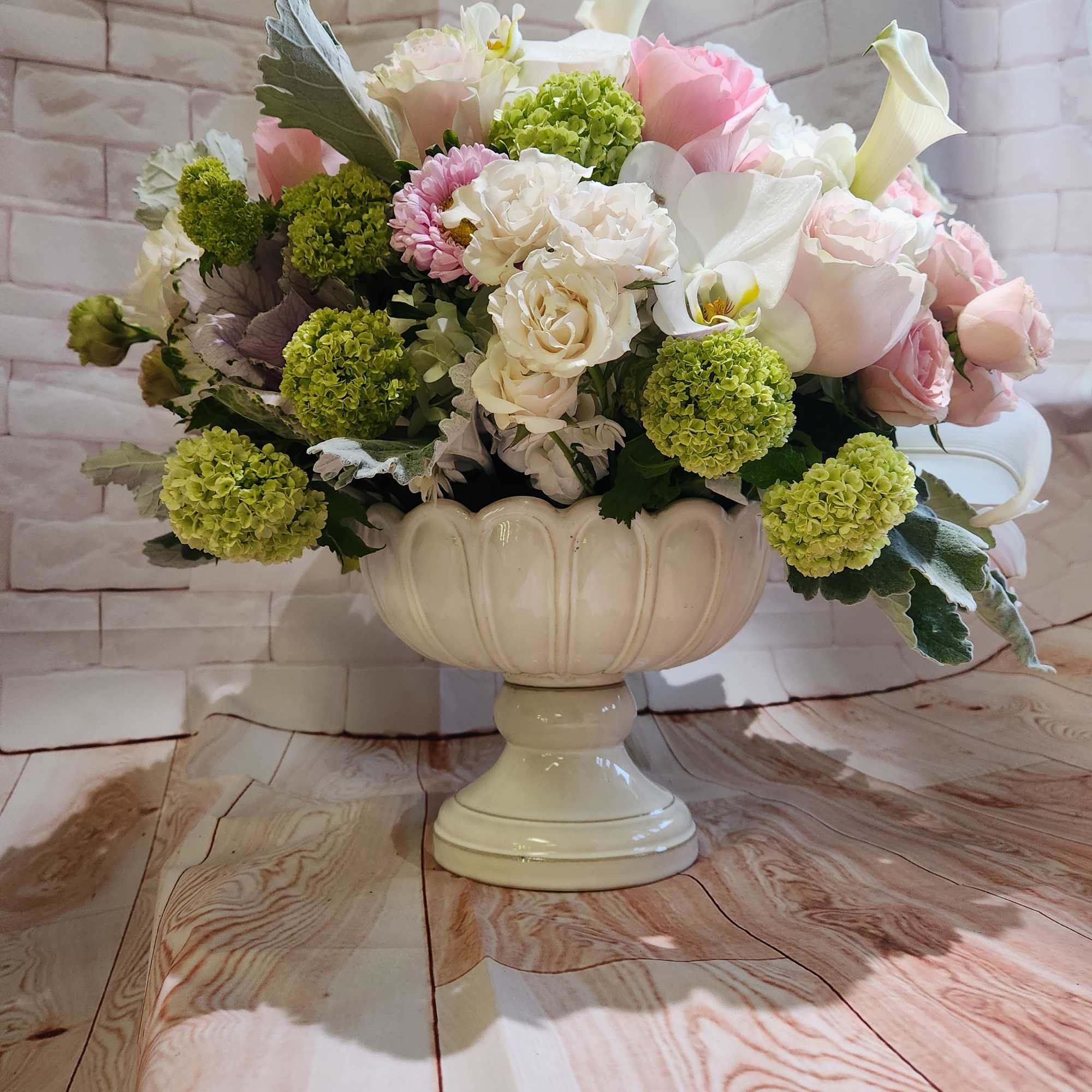 Pastel flower arrangement in a white pedestal vase