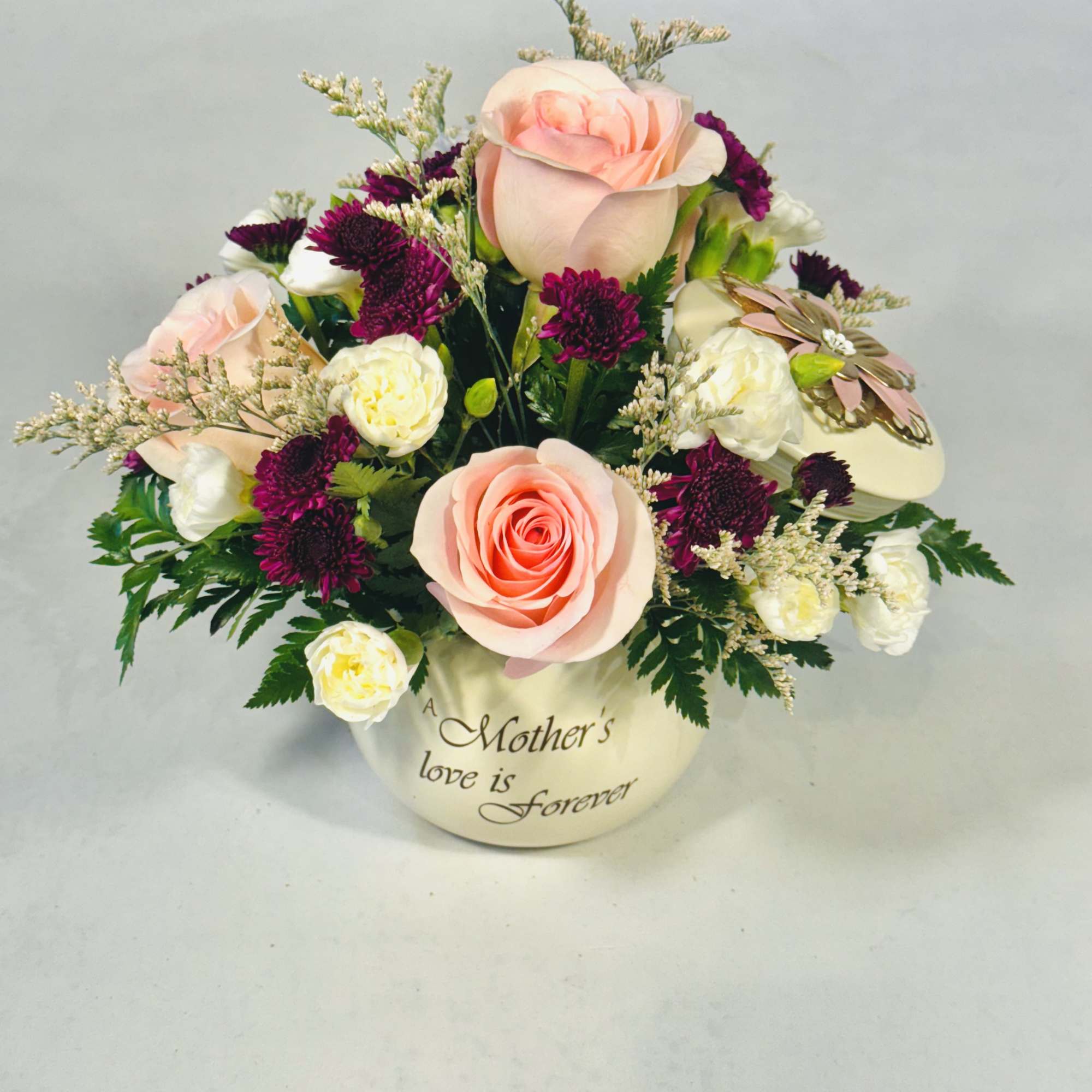 Soft blush pink roses take center stage in this rounded keepsake arrangement