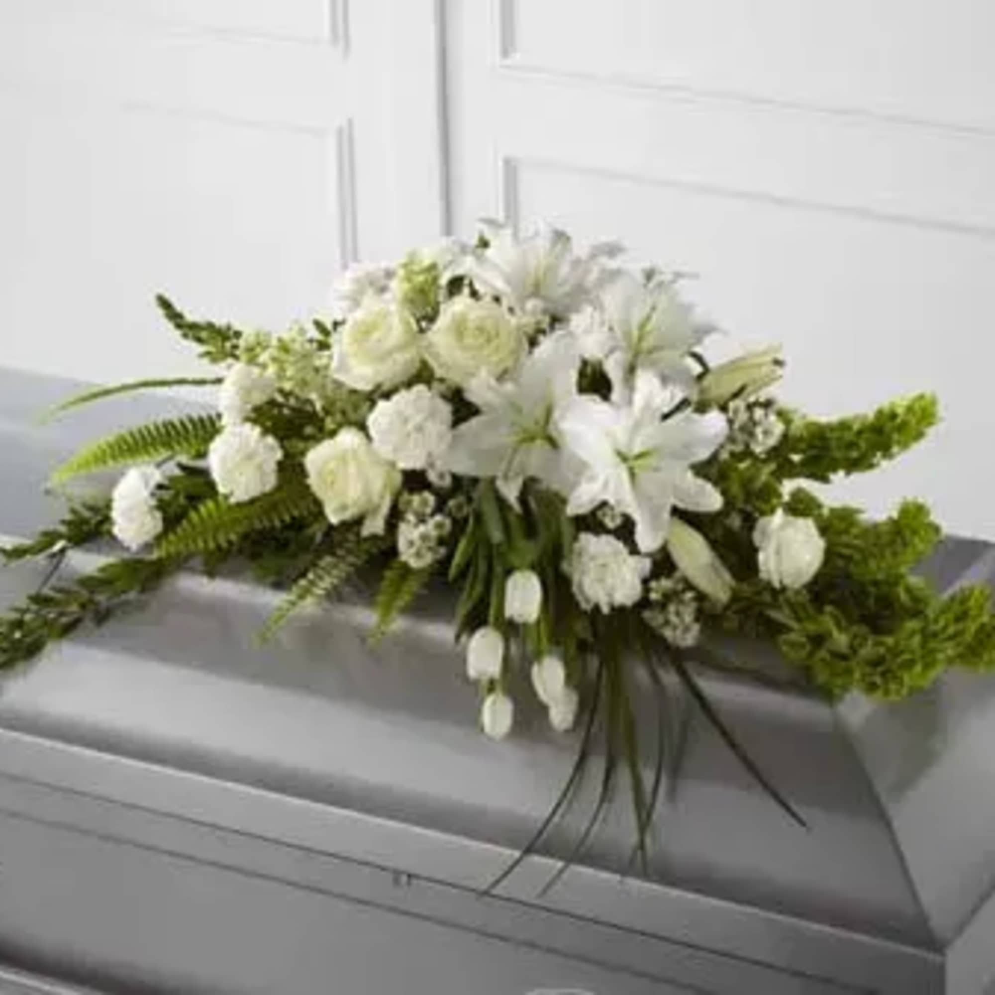 White floral casket spray with lilies and roses