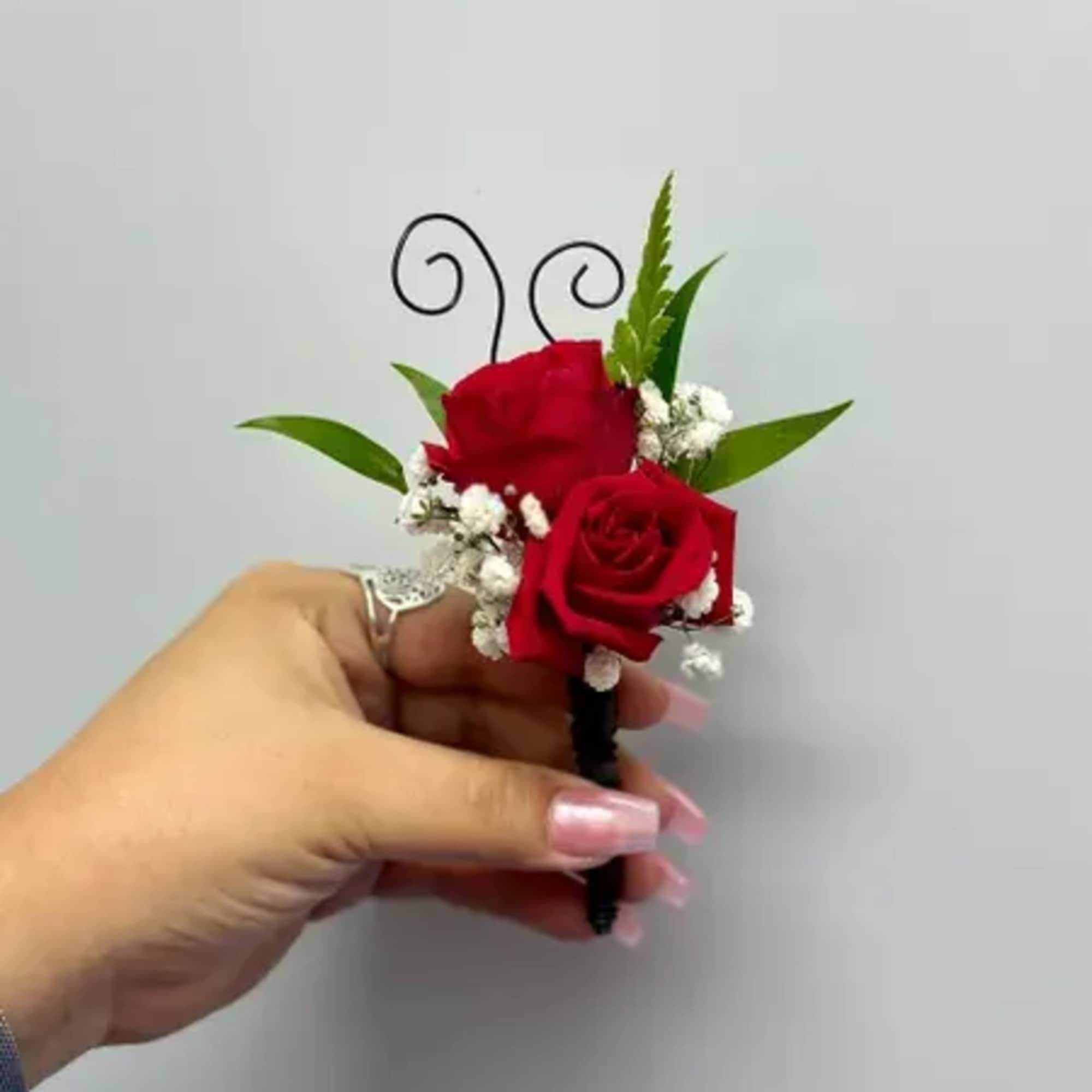 Small red rose boutonniere with baby's breath and greenery