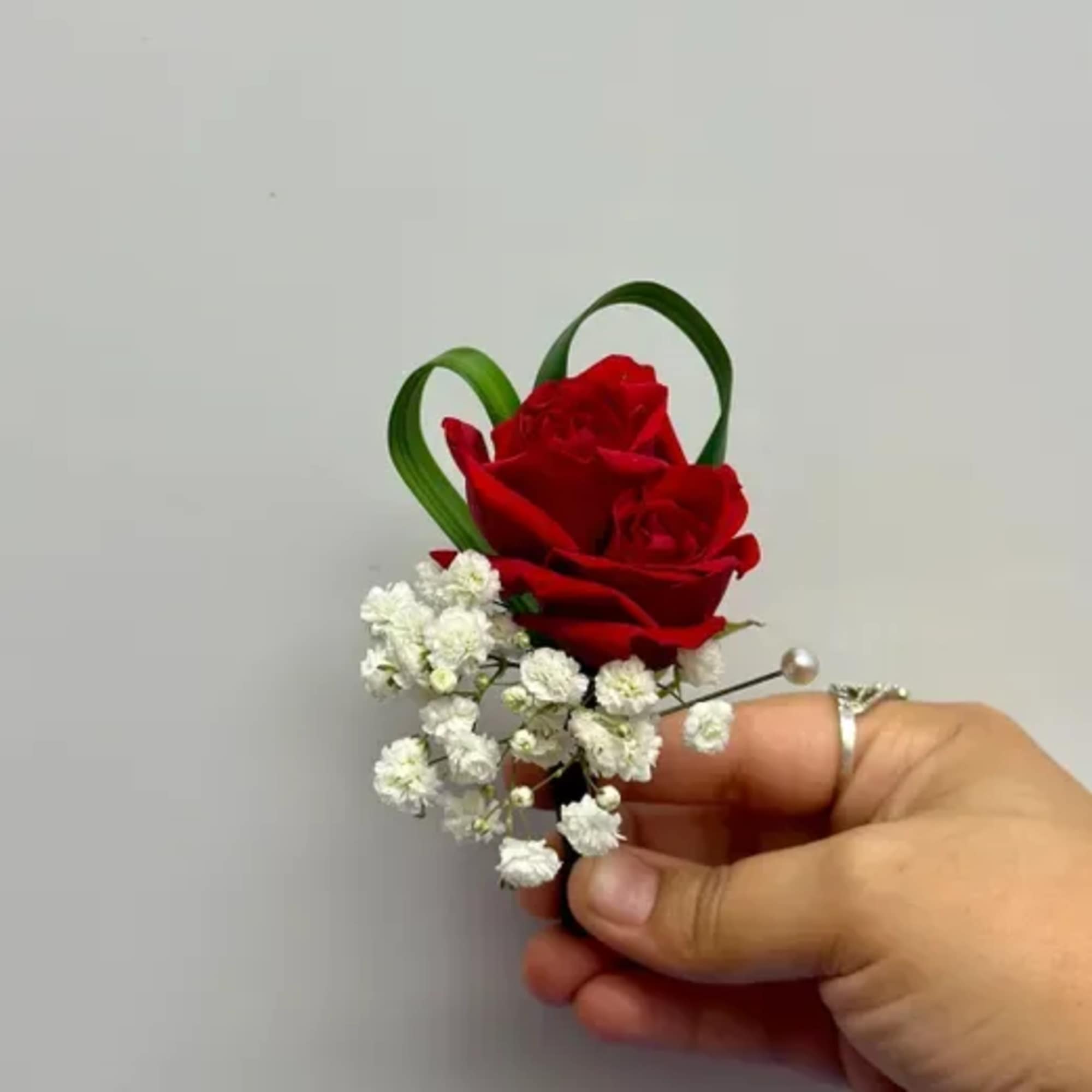 Small red rose boutonniere with white baby's breath