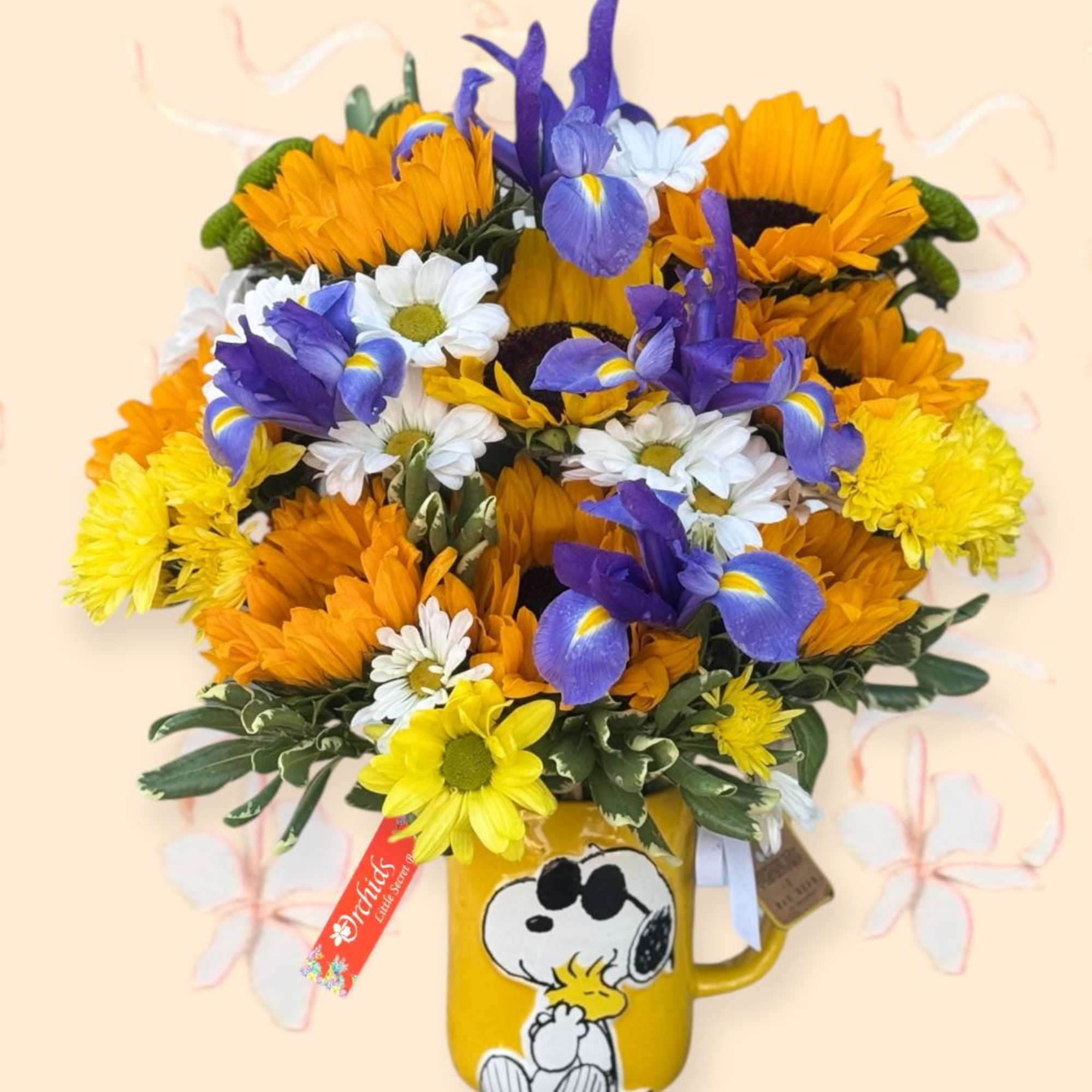 Bouquet of sunflowers, daisies, and purple irises in a Snoopy mug