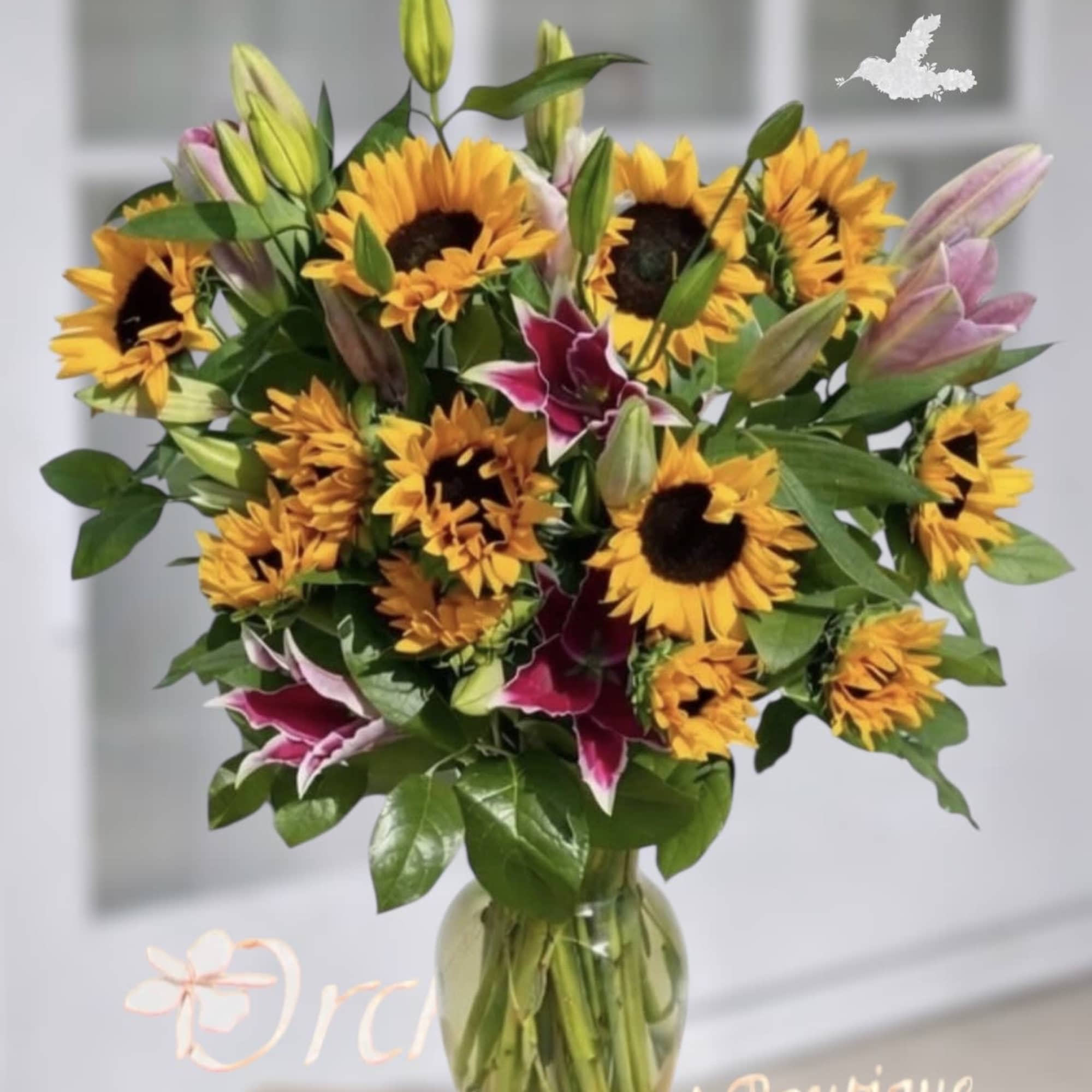 Bouquet of sunflowers and lilies in a glass vase