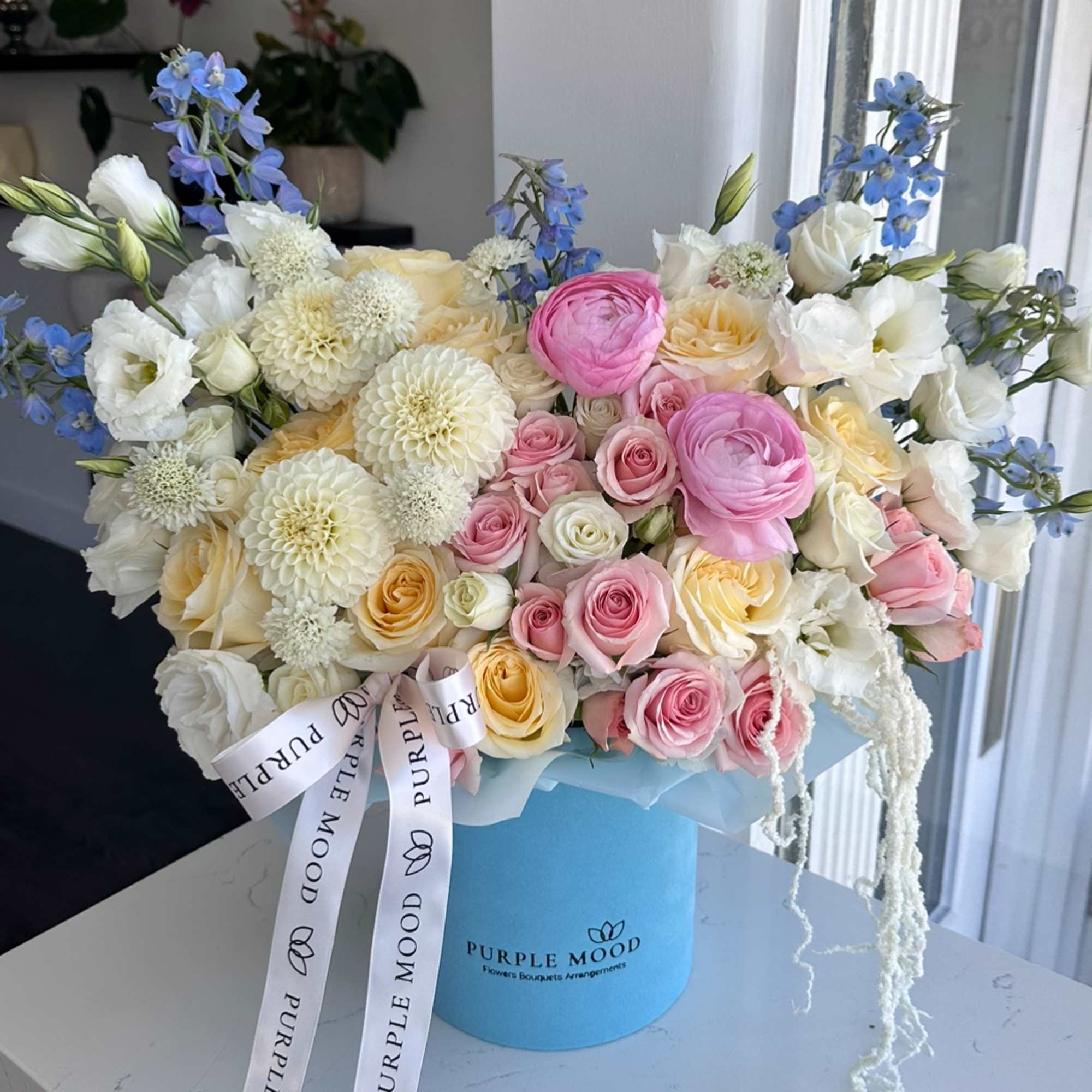 Bouquet of pink, white, and cream flowers in a blue hat box