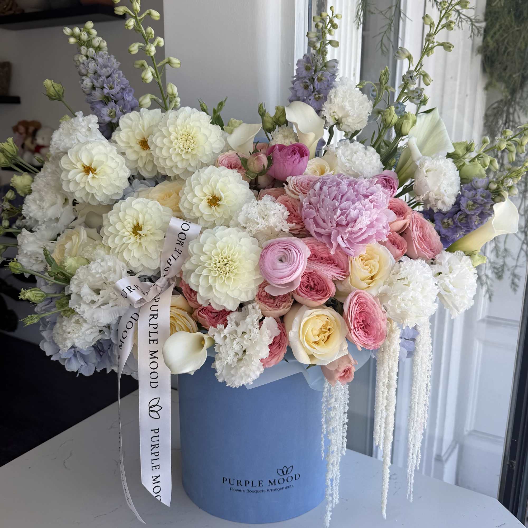 Large pastel bouquet in a blue hatbox with pink, white, and lavender flowers