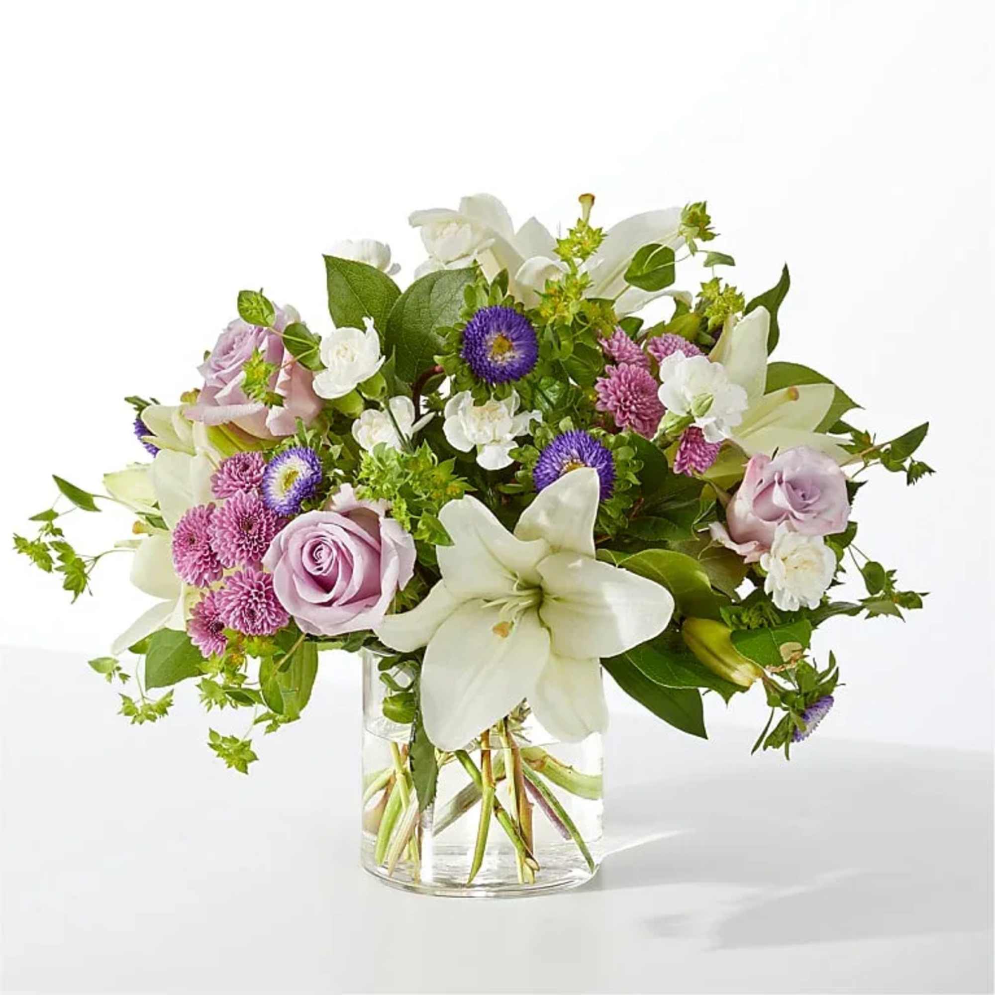 White lilies take center stage in this airy garden-style vase arrangement, a
