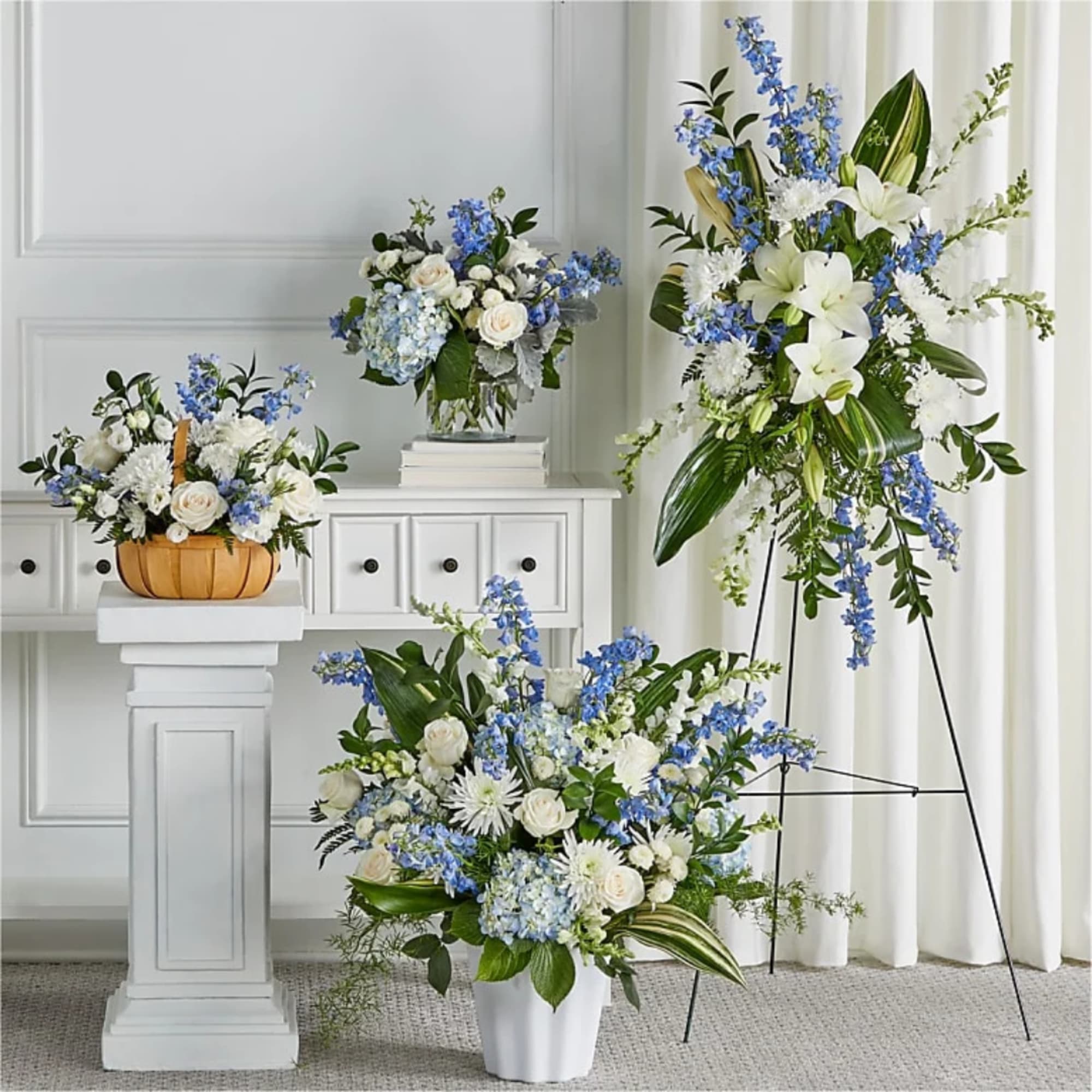 Blue and white floral arrangements in a vase, basket, and standing display