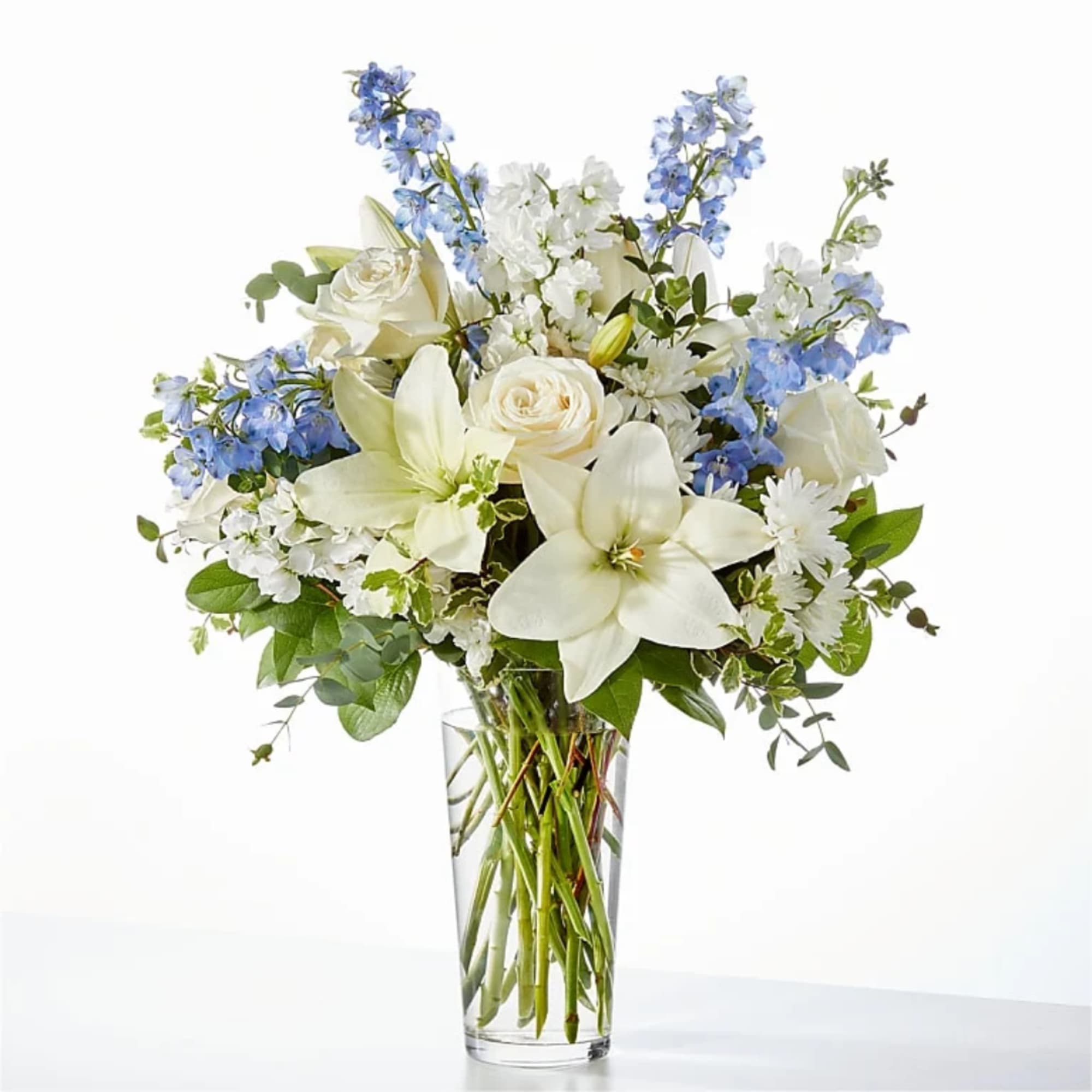 White and blue floral arrangement in a clear glass vase