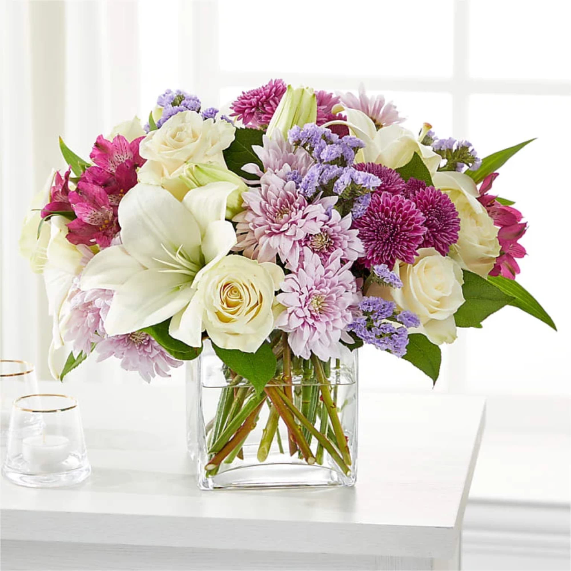 Mixed bouquet of white and pink flowers in a clear glass vase