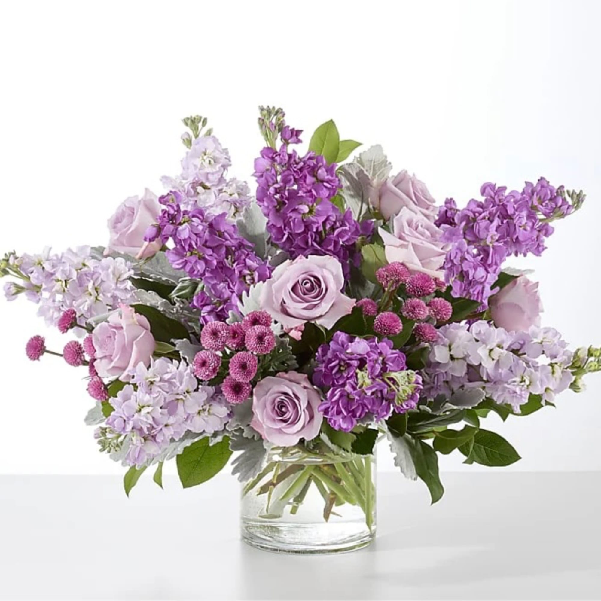 Lavender and purple flower arrangement in a clear glass vase