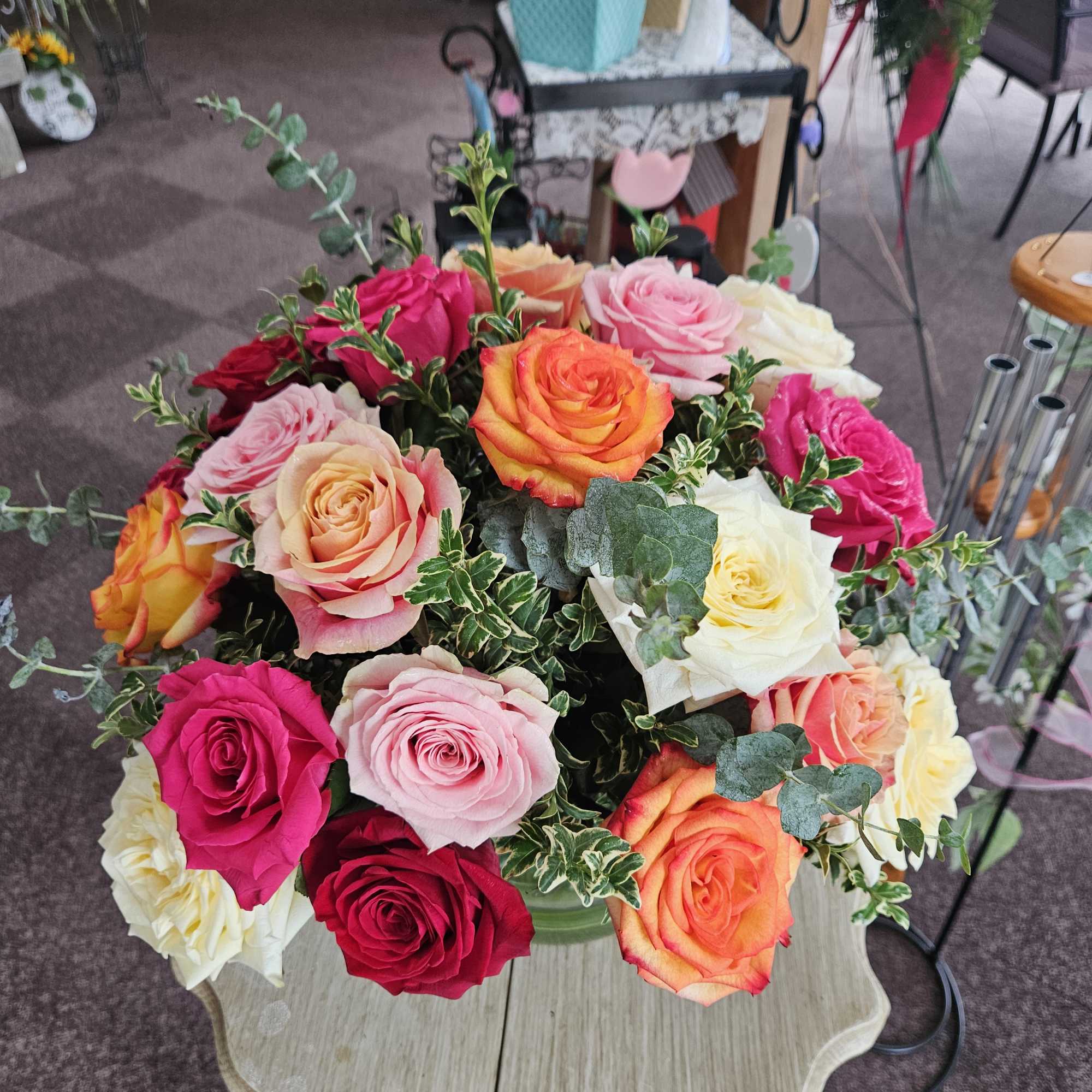 Bouquet of multicolored roses with eucalyptus in a vase