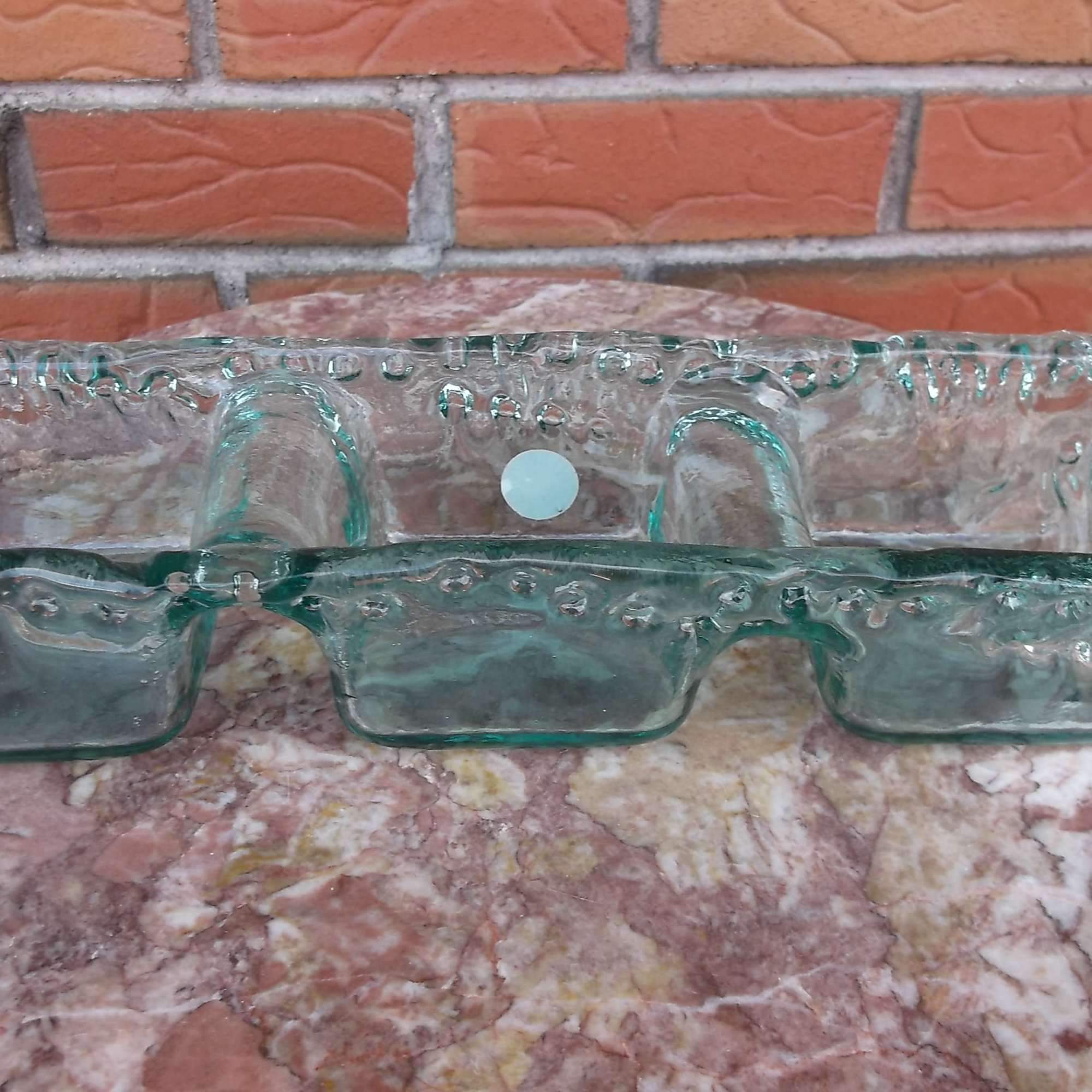 Clear glass divided serving dish on a marble surface