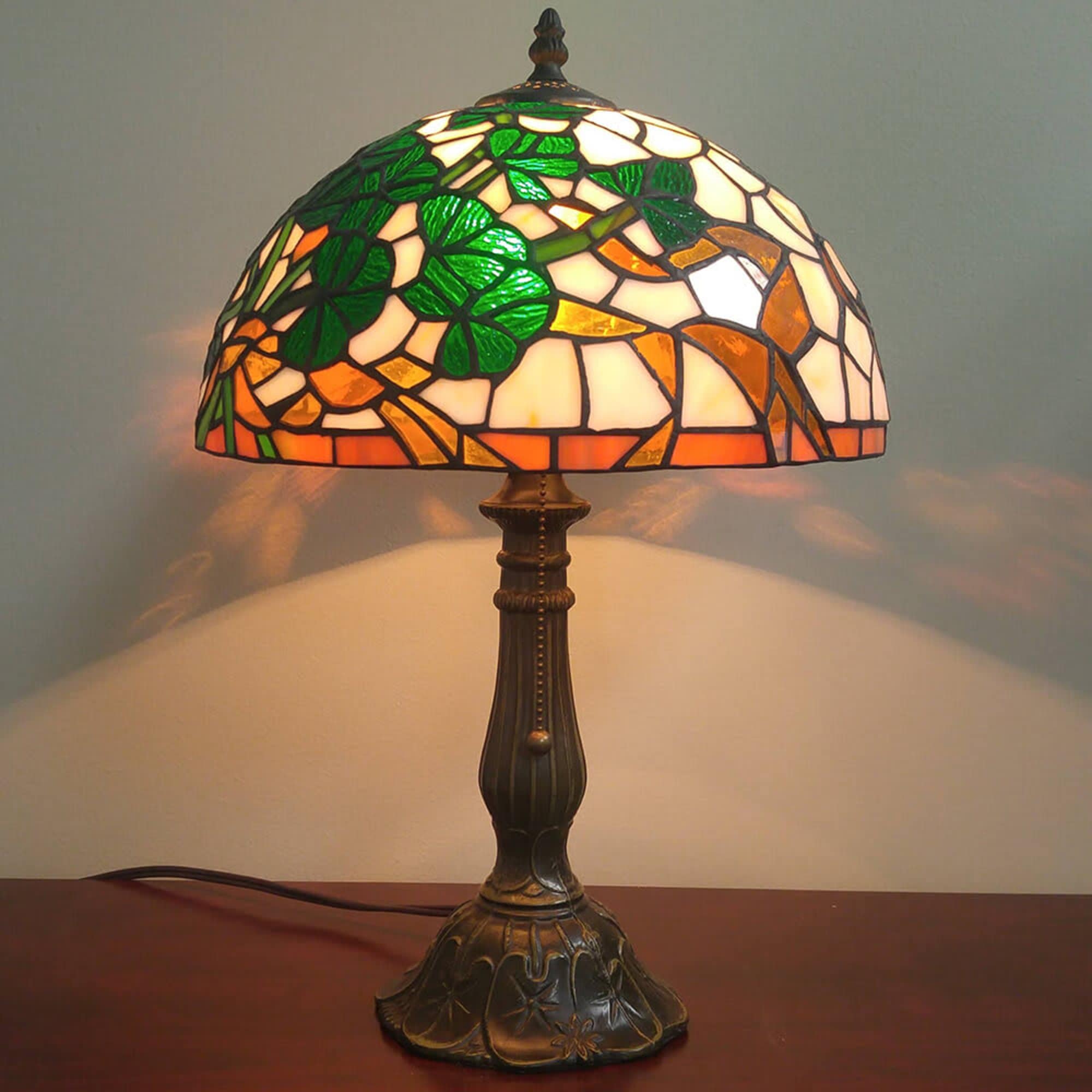 Stained glass table lamp with green, orange, and cream mosaic shade