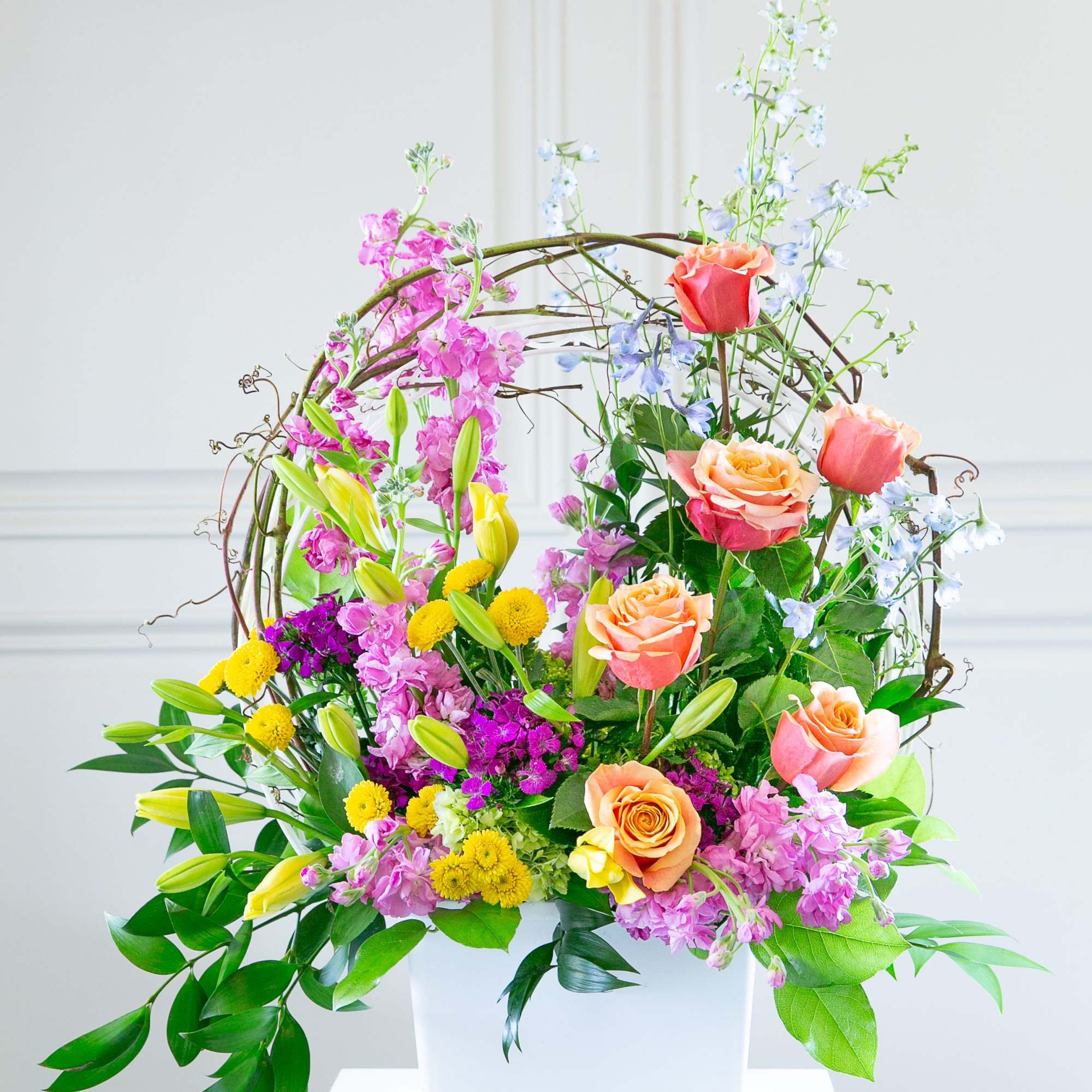 Colorful floral arrangement in a white container with roses and lilies