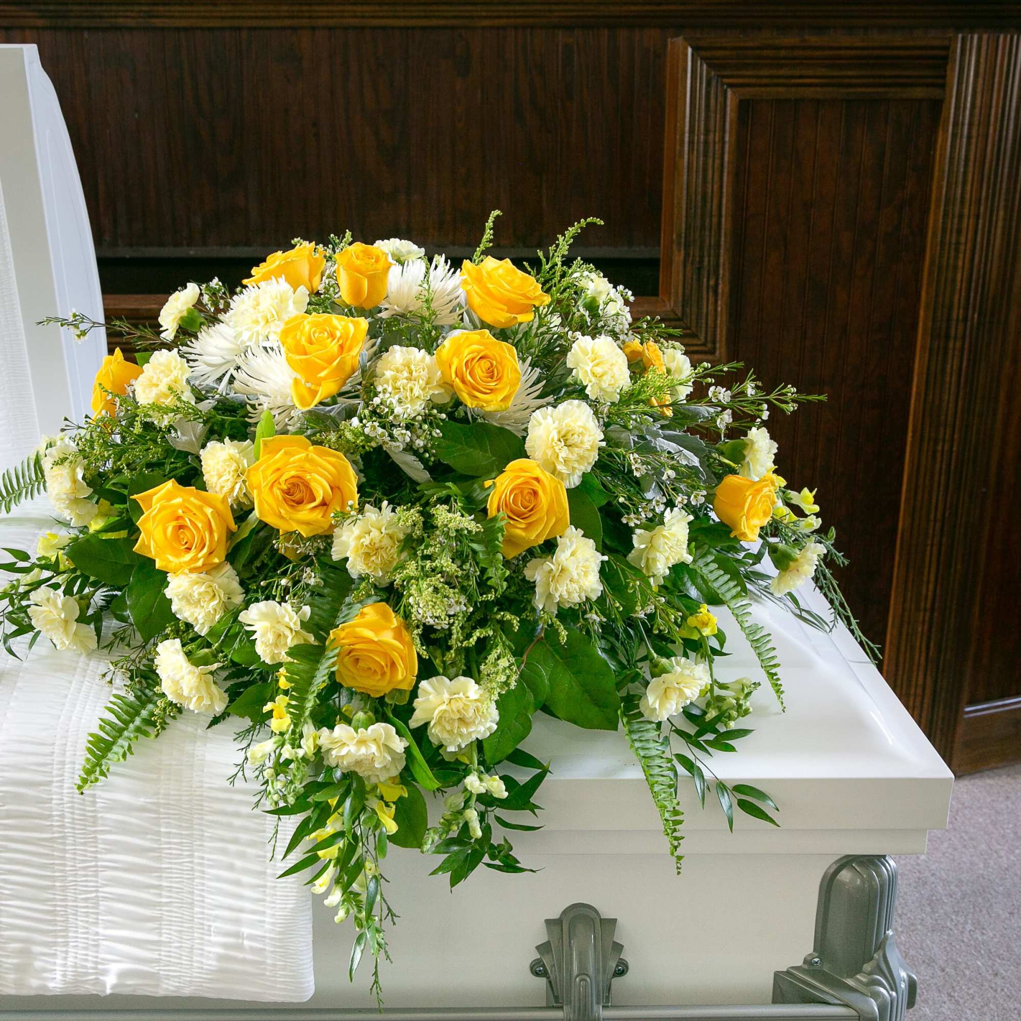 Yellow and white floral casket spray with roses and carnations