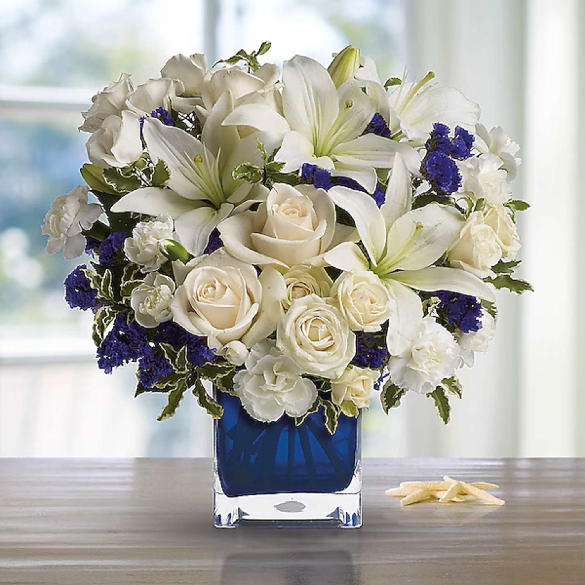 White lilies and roses arranged in a blue glass vase, photo 2 of 2