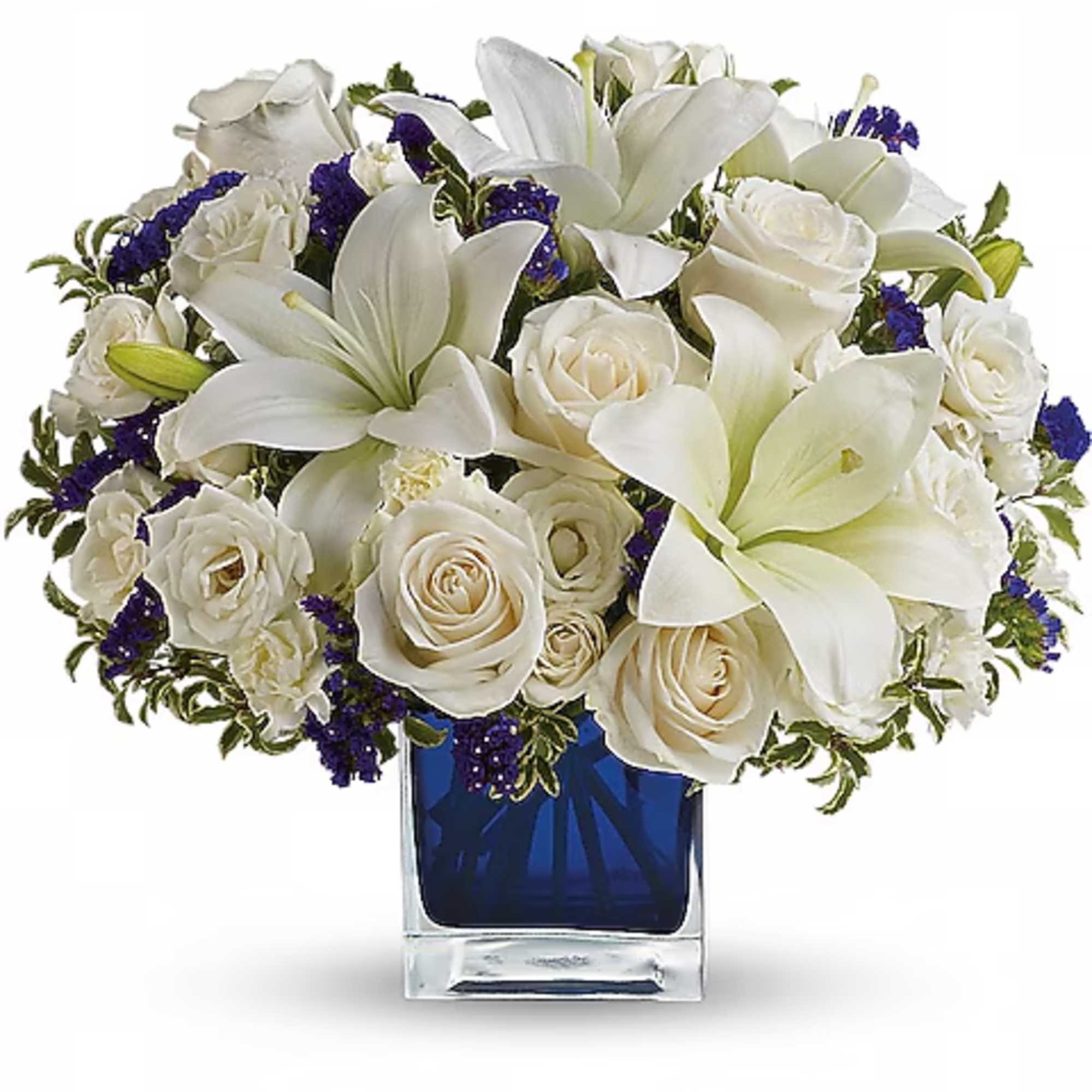 White roses and lilies arranged in a blue glass vase