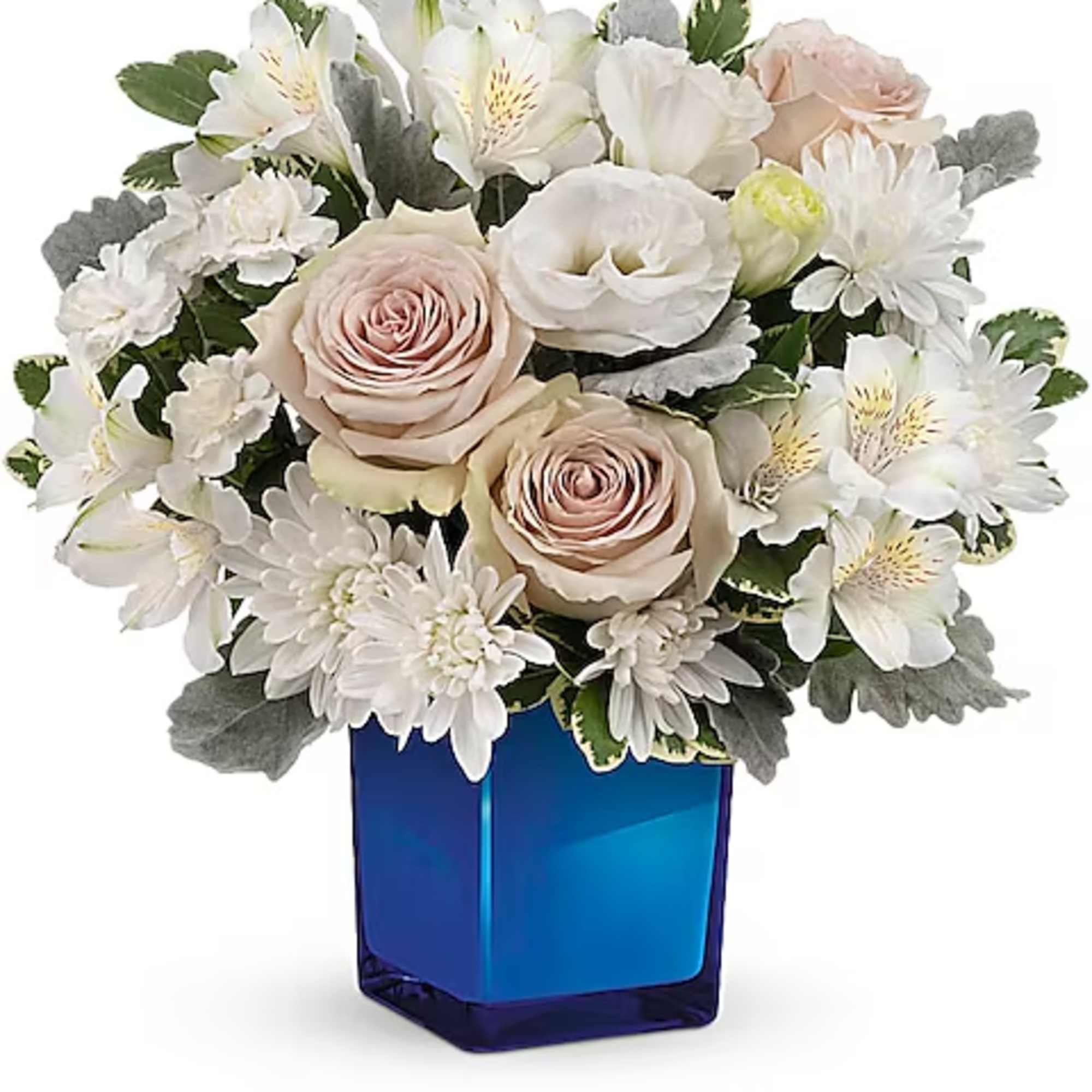 White and blush flowers arranged in a blue glass vase