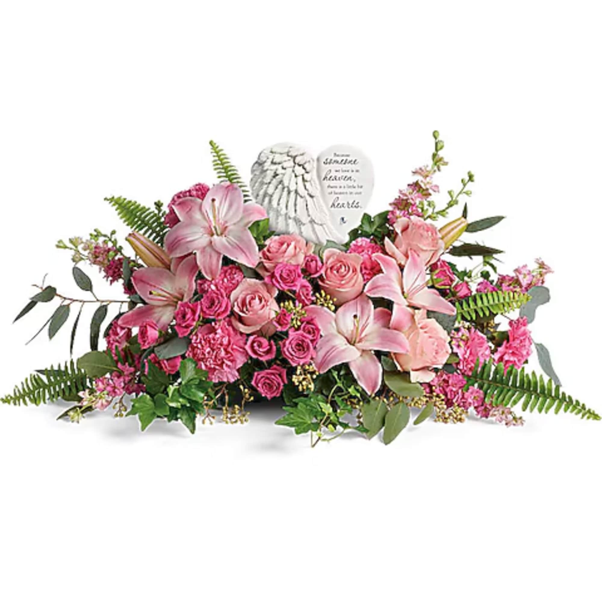 Pink lilies and roses arranged around a heart-shaped memorial stone