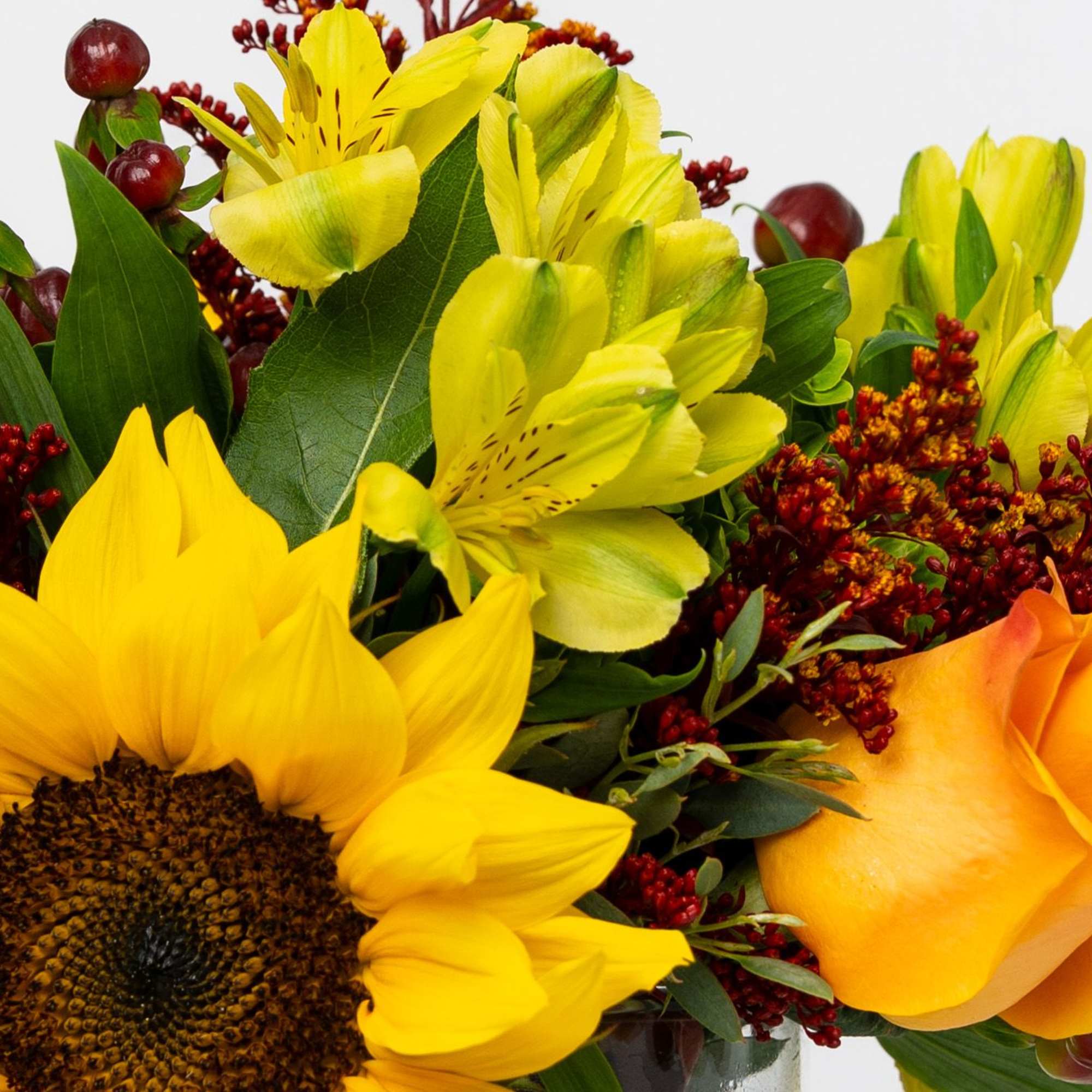 Sunflowers, yellow alstroemeria, and an orange rose in a vase