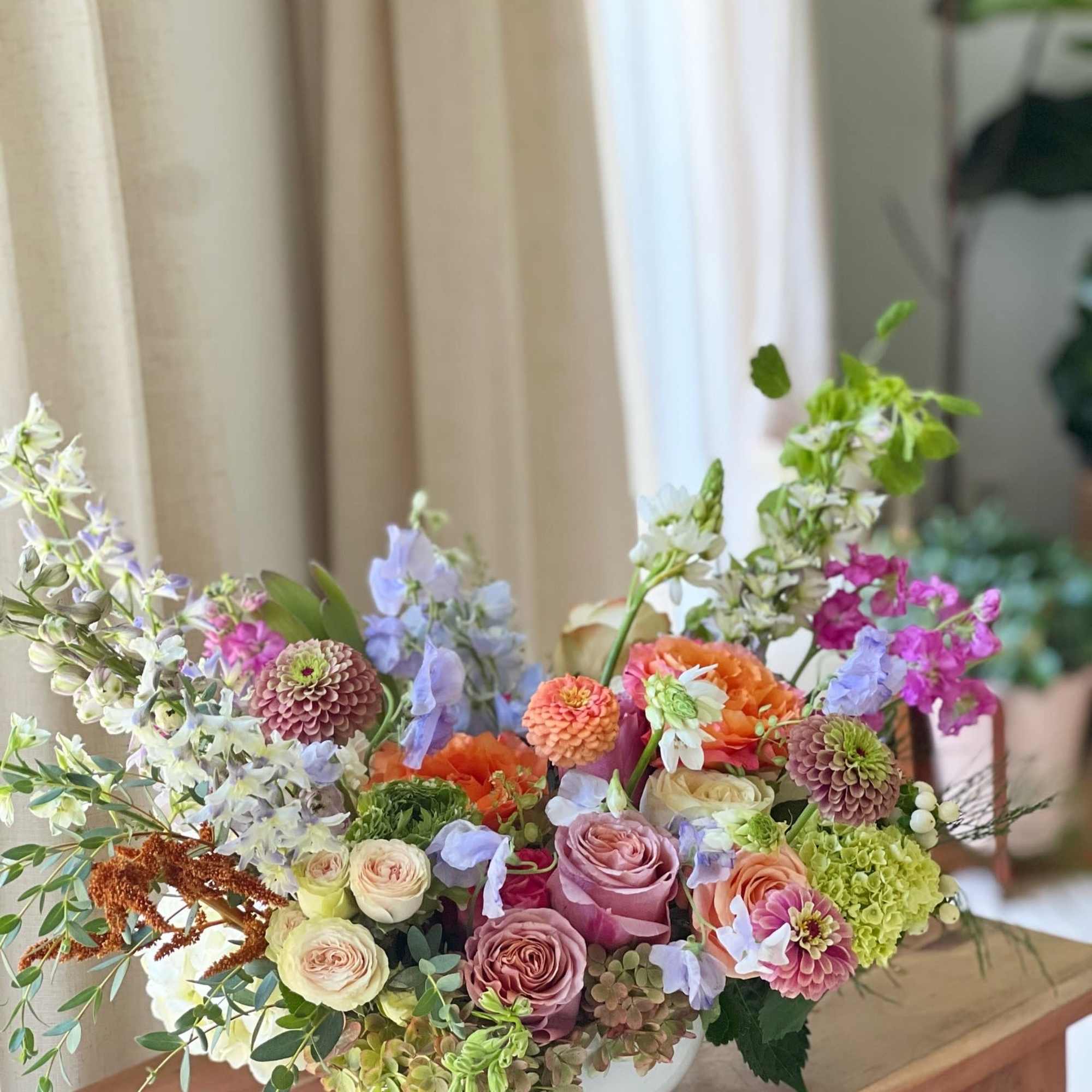 Colorful mixed flower arrangement in a white bowl vase
