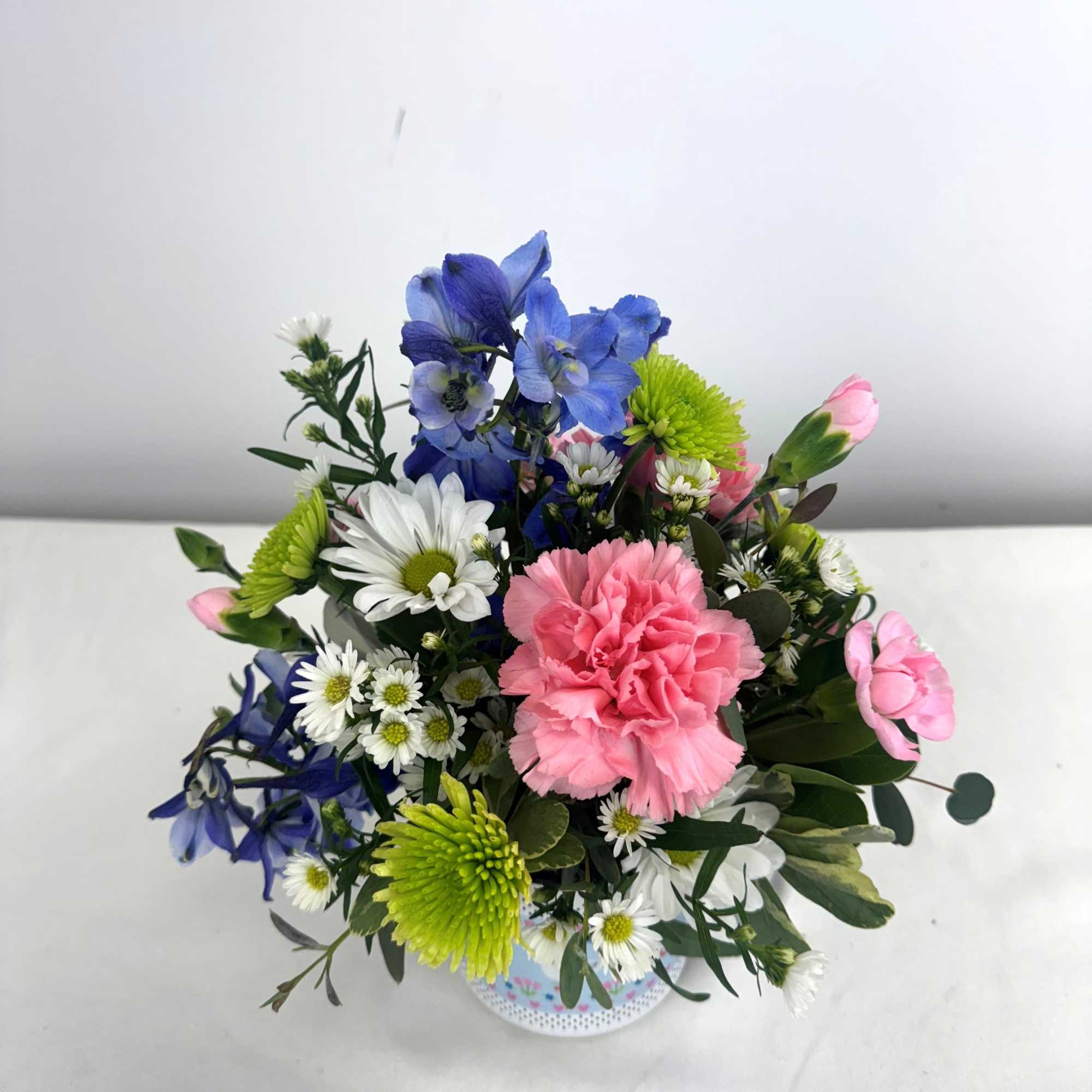 Mixed pink carnations, blue blooms, white daisies and green mums arranged in, photo 2 of 3