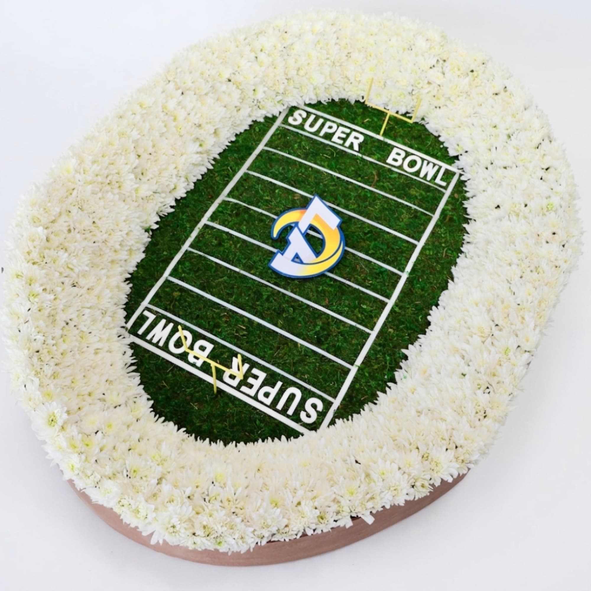Football field floral tribute with white flowers arranged around a Super Bowl design