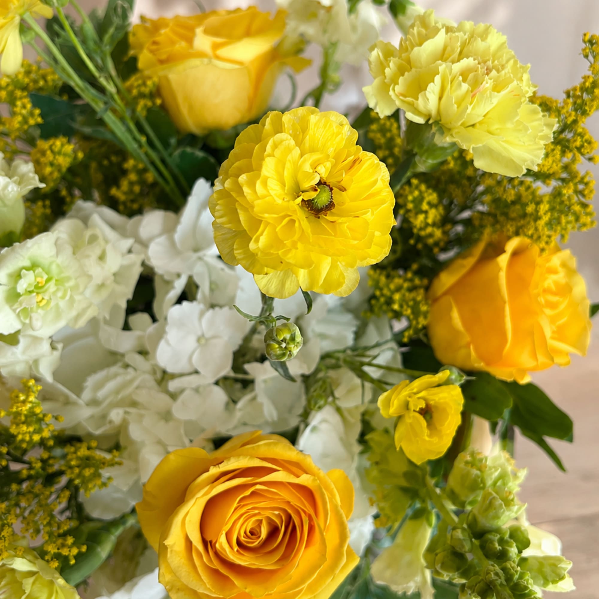 Yellow and white flower bouquet in a glass vase