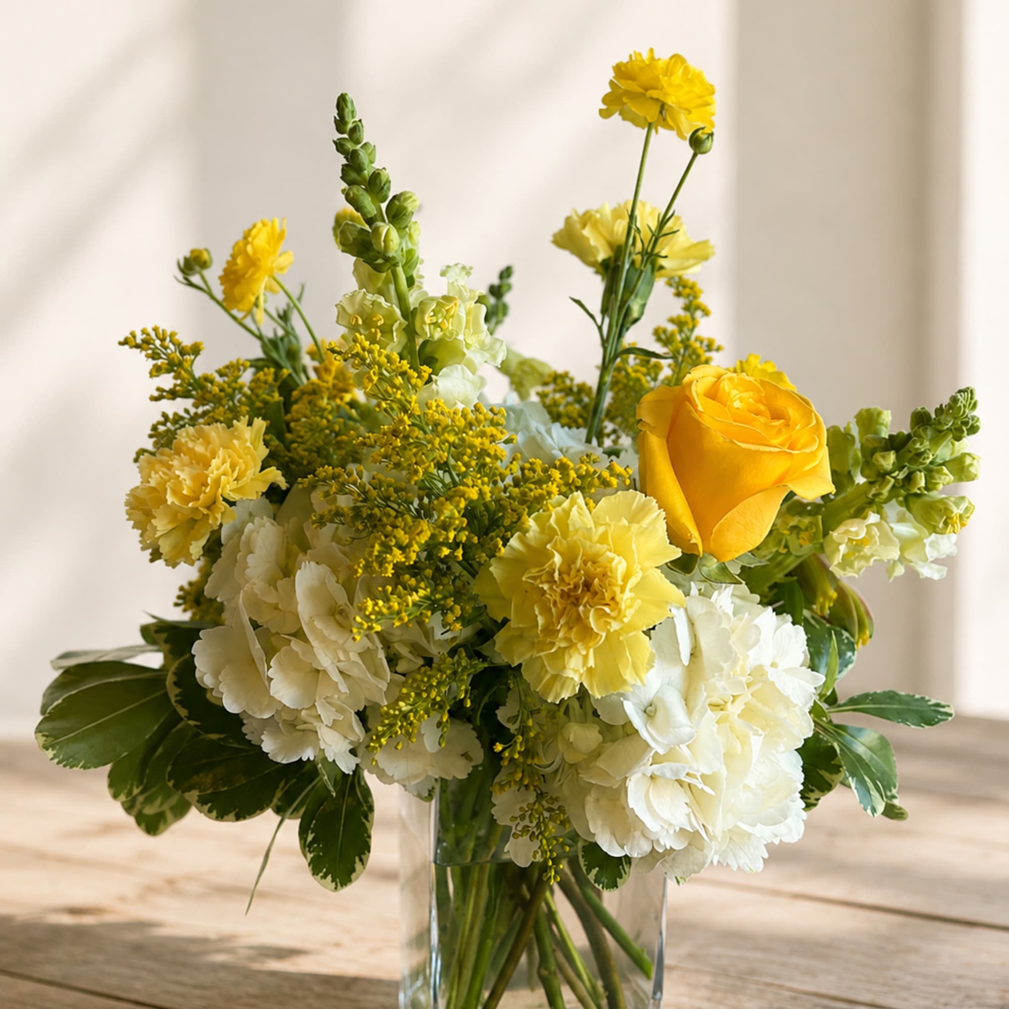 Yellow and white floral arrangement in a clear glass vase