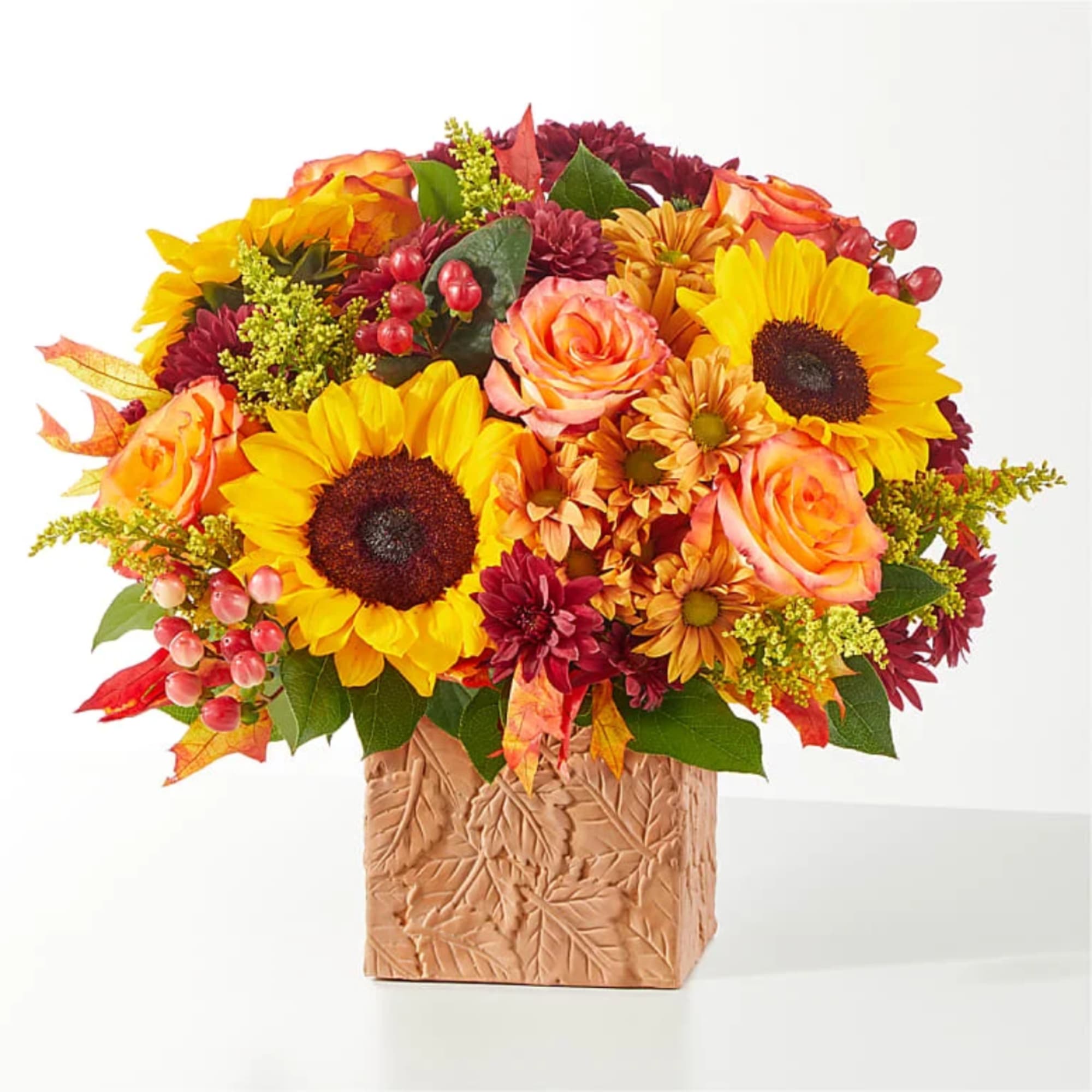 Autumn bouquet with sunflowers, roses, and mums in a textured square vase