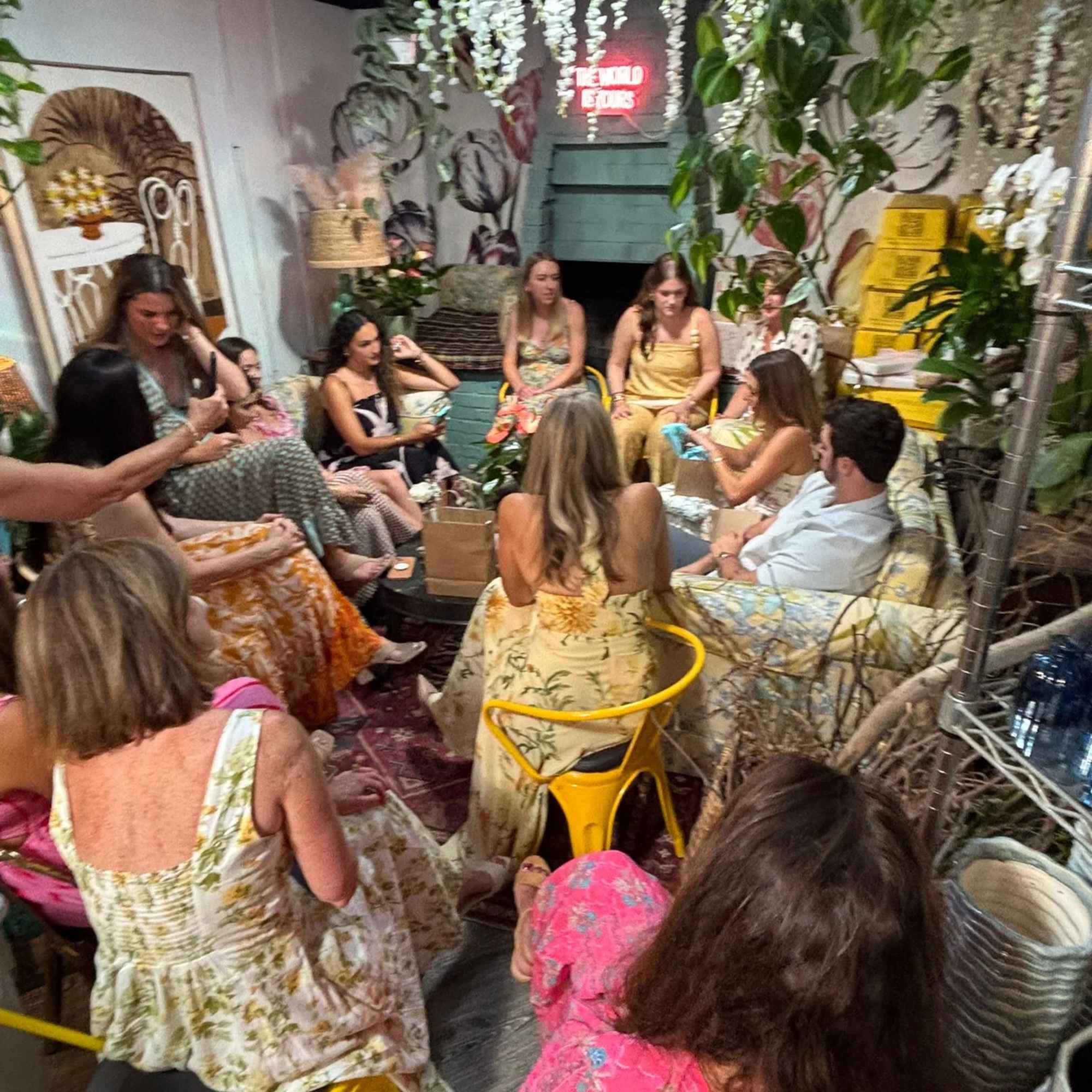 Group seated in a flower-filled room with hanging white blooms