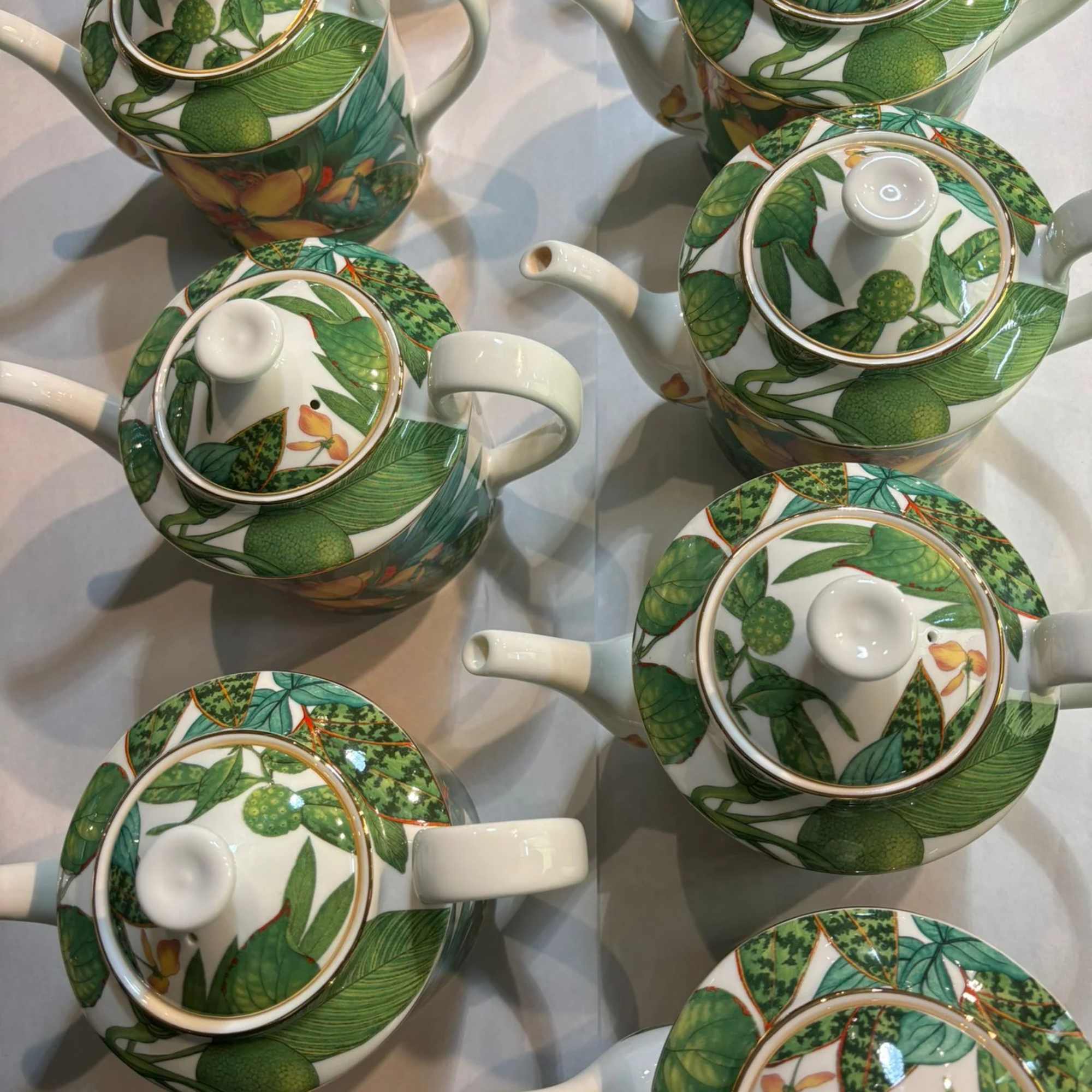 Patterned ceramic teapots with green leaf and fruit designs