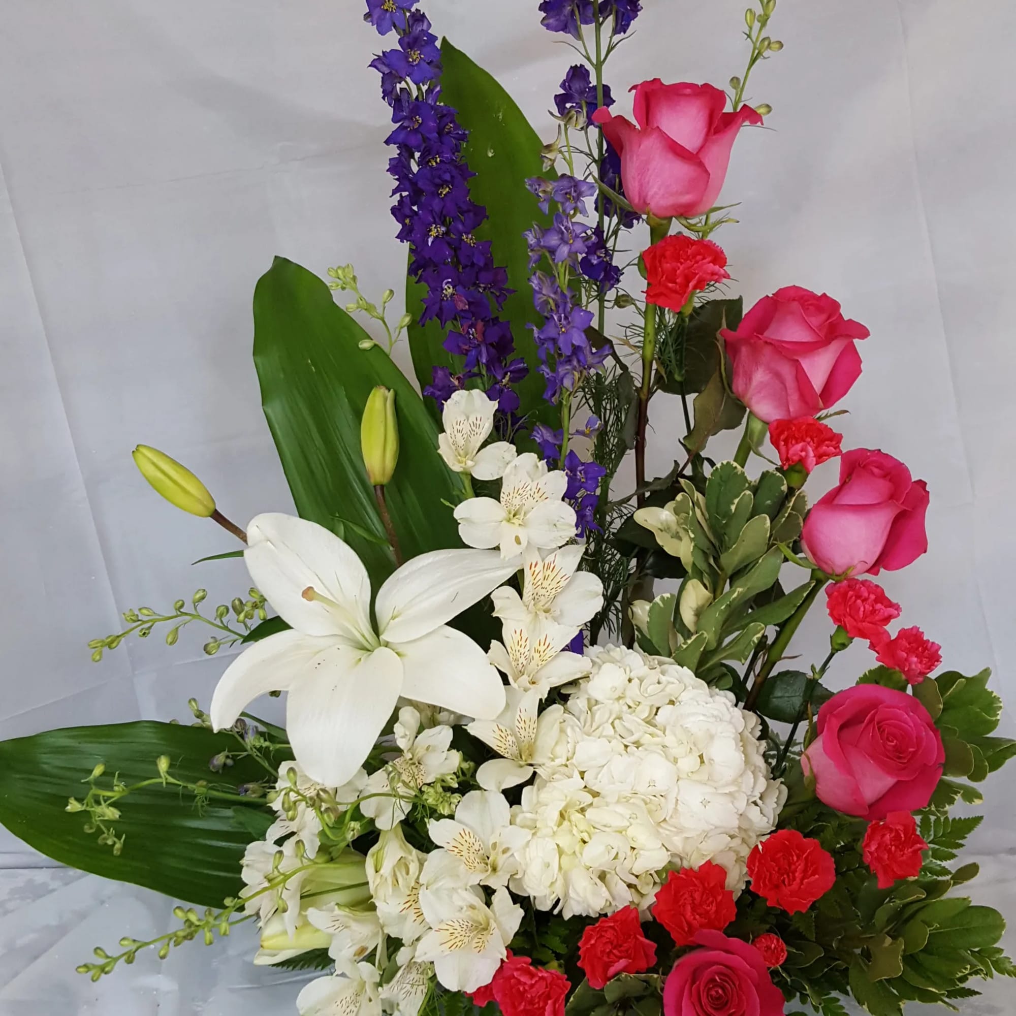 Bouquet of pink roses, white lilies, and purple delphinium