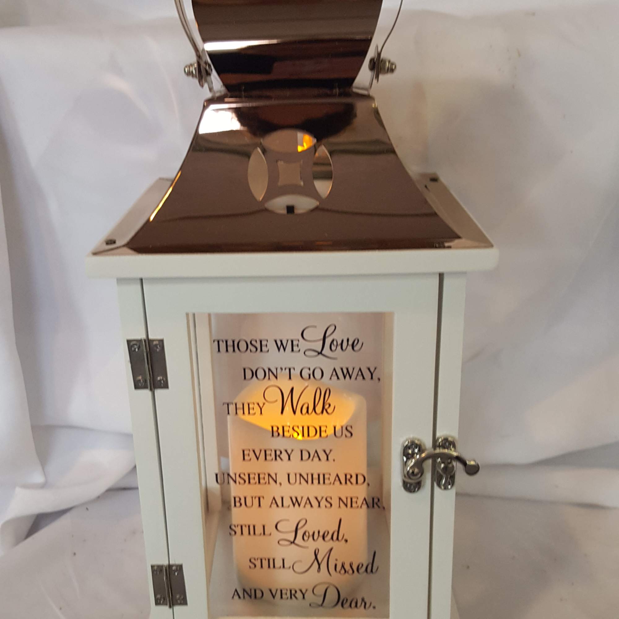 White memorial lantern with a candle and sympathy message