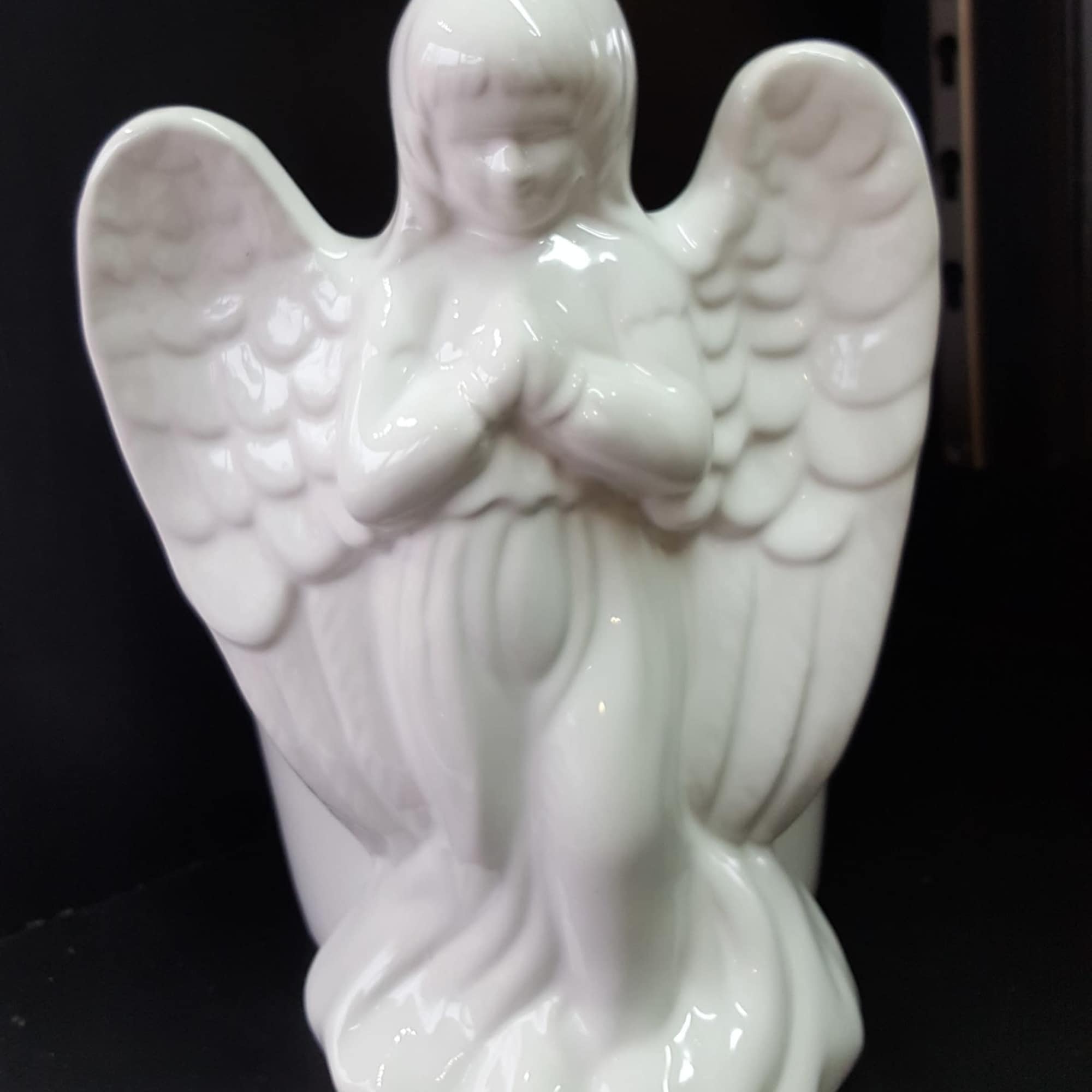 White ceramic angel figurine with folded hands